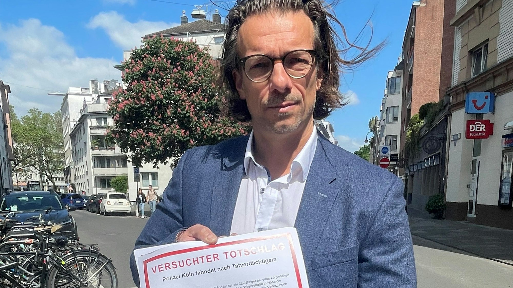 Dirk Bachem hält ein Plakat in der Hand auf dem „Versuchter Totschlag“ steht.