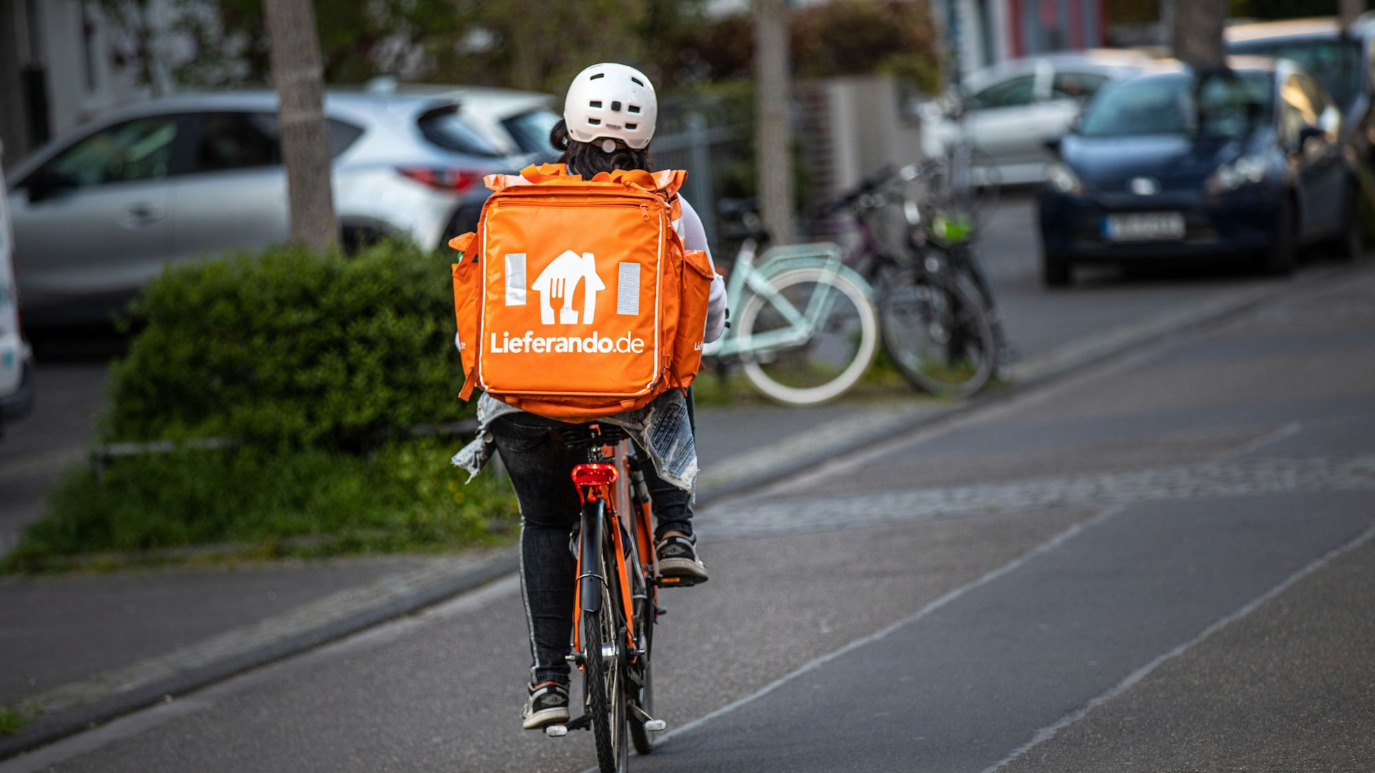 Ein Fahrer des Lieferdienstes Lieferando.de von hinten auf der Straße