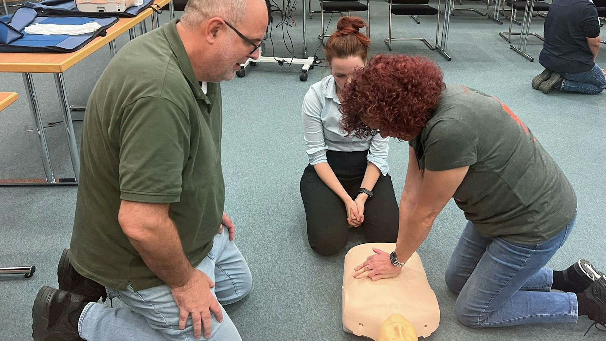 Das Ehepaar Heutz übt unter Anleitung an einer Puppe im Kreishaus die Herzdruckmassage.