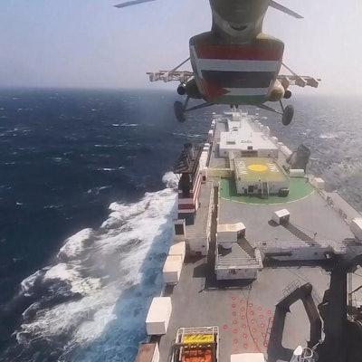 This photo released by the Houthi Media Center shows a Houthi forces helicopter approaching the cargo ship Galaxy Leader on Sunday, Nov. 19, 2023. Yemen's Houthis have seized the ship in the Red Sea off the coast of Yemen after threatening to seize all vessels owned by Israeli companies. (Houthi Media Center via AP)