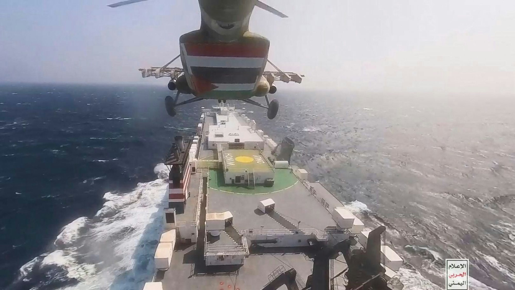 This photo released by the Houthi Media Center shows a Houthi forces helicopter approaching the cargo ship Galaxy Leader on Sunday, Nov. 19, 2023. Yemen's Houthis have seized the ship in the Red Sea off the coast of Yemen after threatening to seize all vessels owned by Israeli companies. (Houthi Media Center via AP)