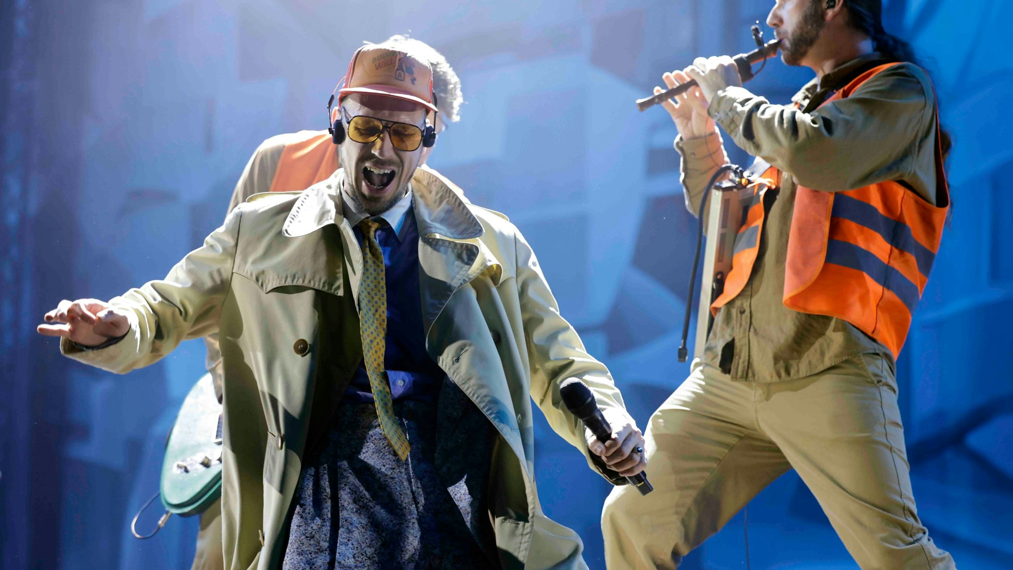 Ein Mann mit Cap und Sonnenbrille steht auf einer Bühne.