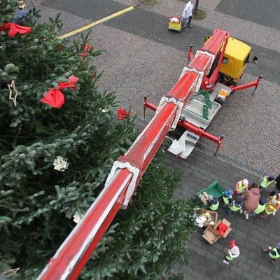 Blick von einer Hubbühne auf einen Weihnachtsbaum, den Markt und eine Gruppe von Kindern