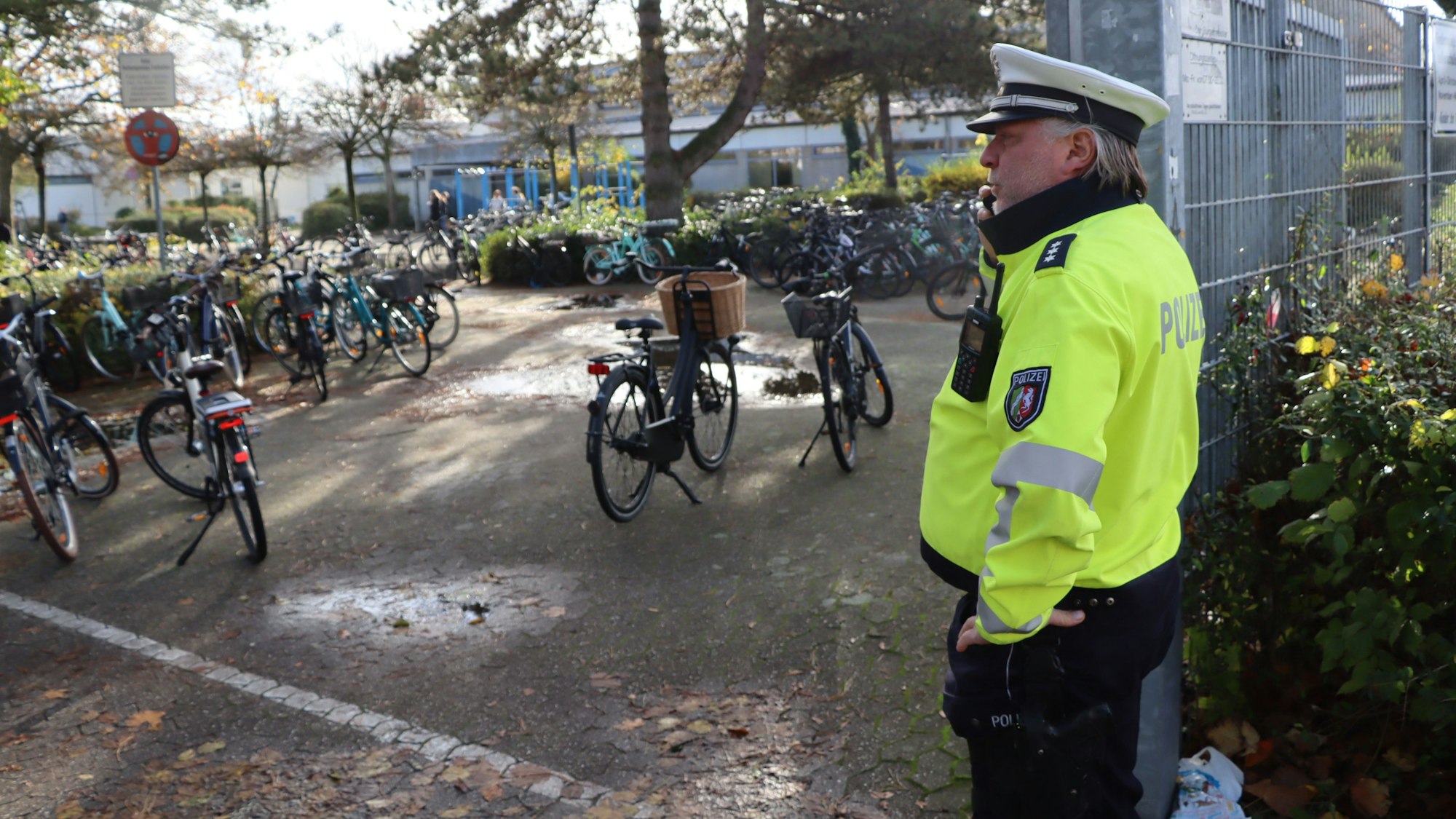 Auf dem Foto ist der Bezirksbeamte Frank Rosenbaum vor dem Schulzentrum zu sehen.