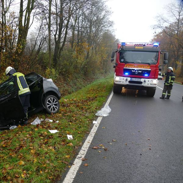 Ein schwarzer PKW liegt nach dem Zusammenstoß bei Pohlhausen auf der B56 mit deutlichen Unfallspuren in einem Graben, die Motorhaube steht offen. Ein Feuerwehrmann beugt sich über das Fahrzeug.