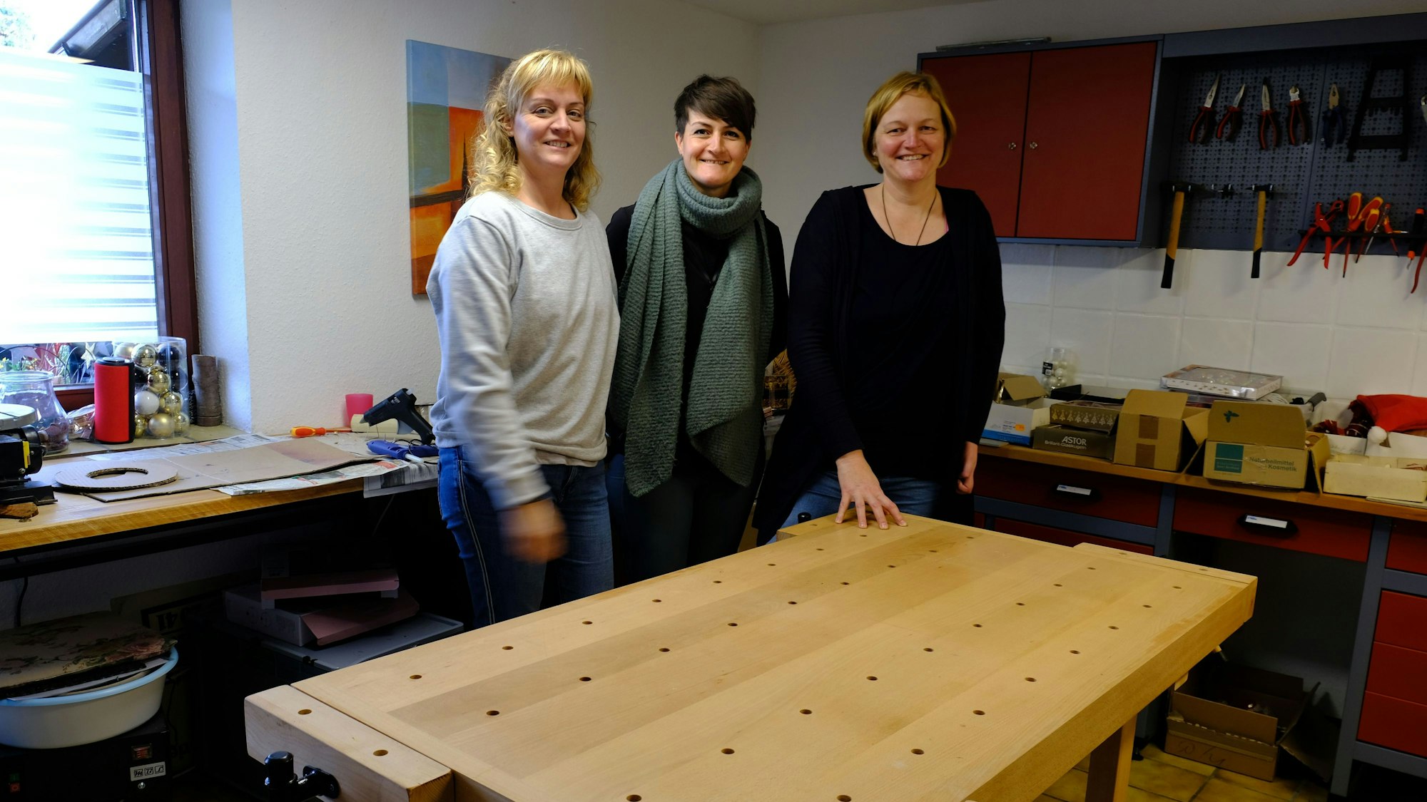 Andrea Hambach, Elena Kramer und Angela Hoch (v.l.) stehen an einer Werkbank.