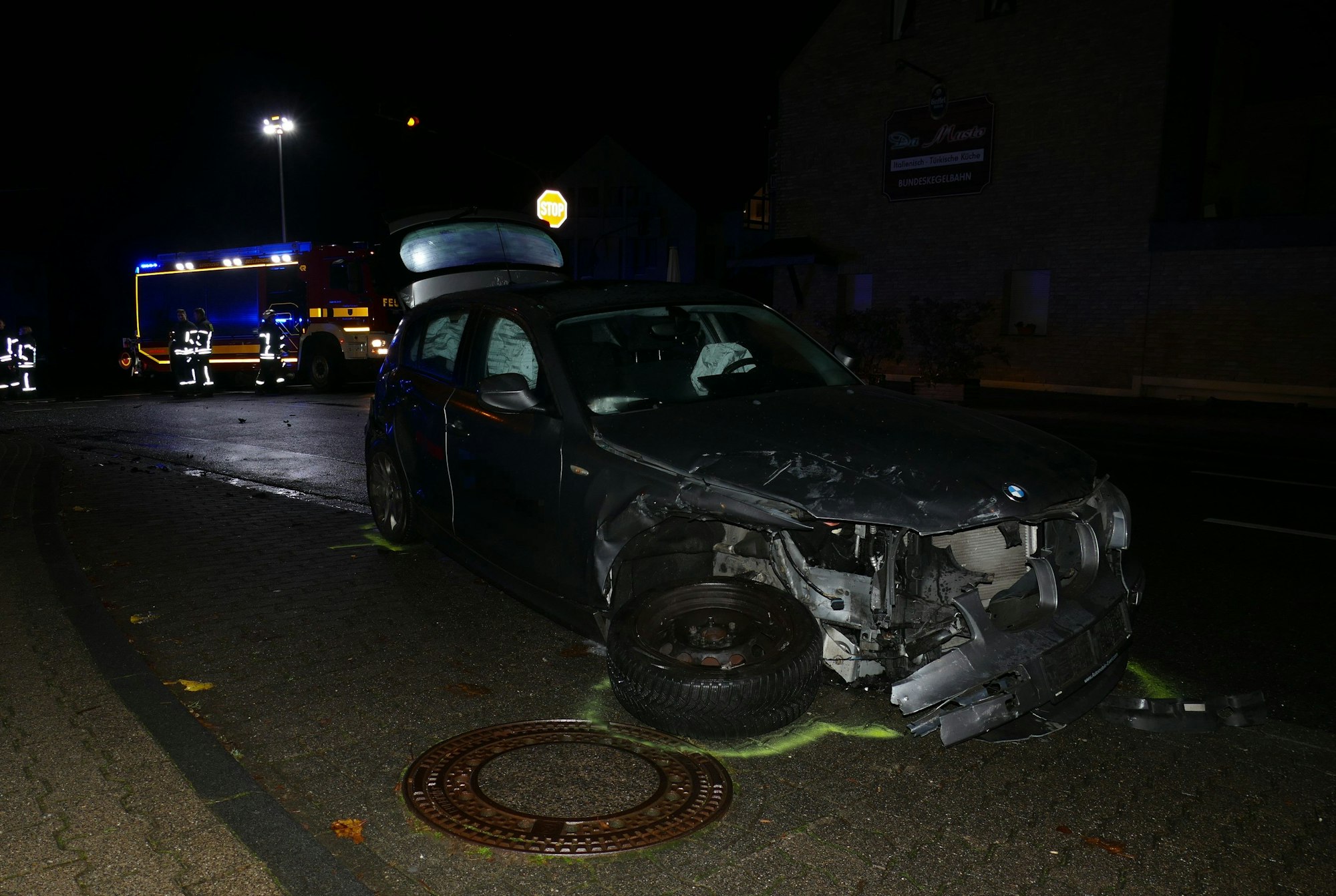 Ein Auto mit abgerissenem Vorderrad steht in einer Bushaltebucht.
