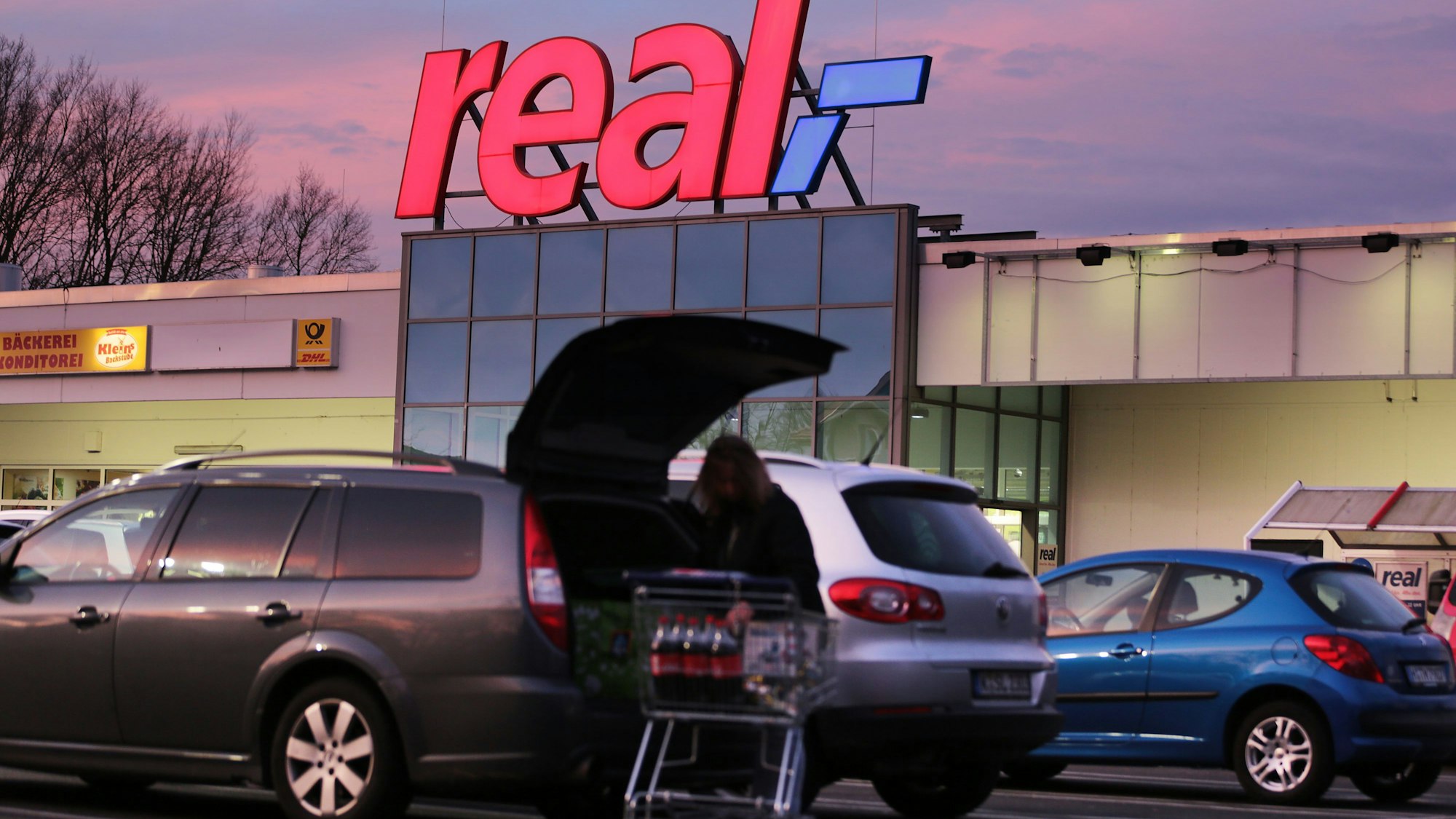 Das Logo leuchtet am Morgen auf dem Dach eines Real Supermarktes. Der Metro Konzern plant den Verkauf der SB-Warenhauskette Real. +++ dpa-Bildfunk +++