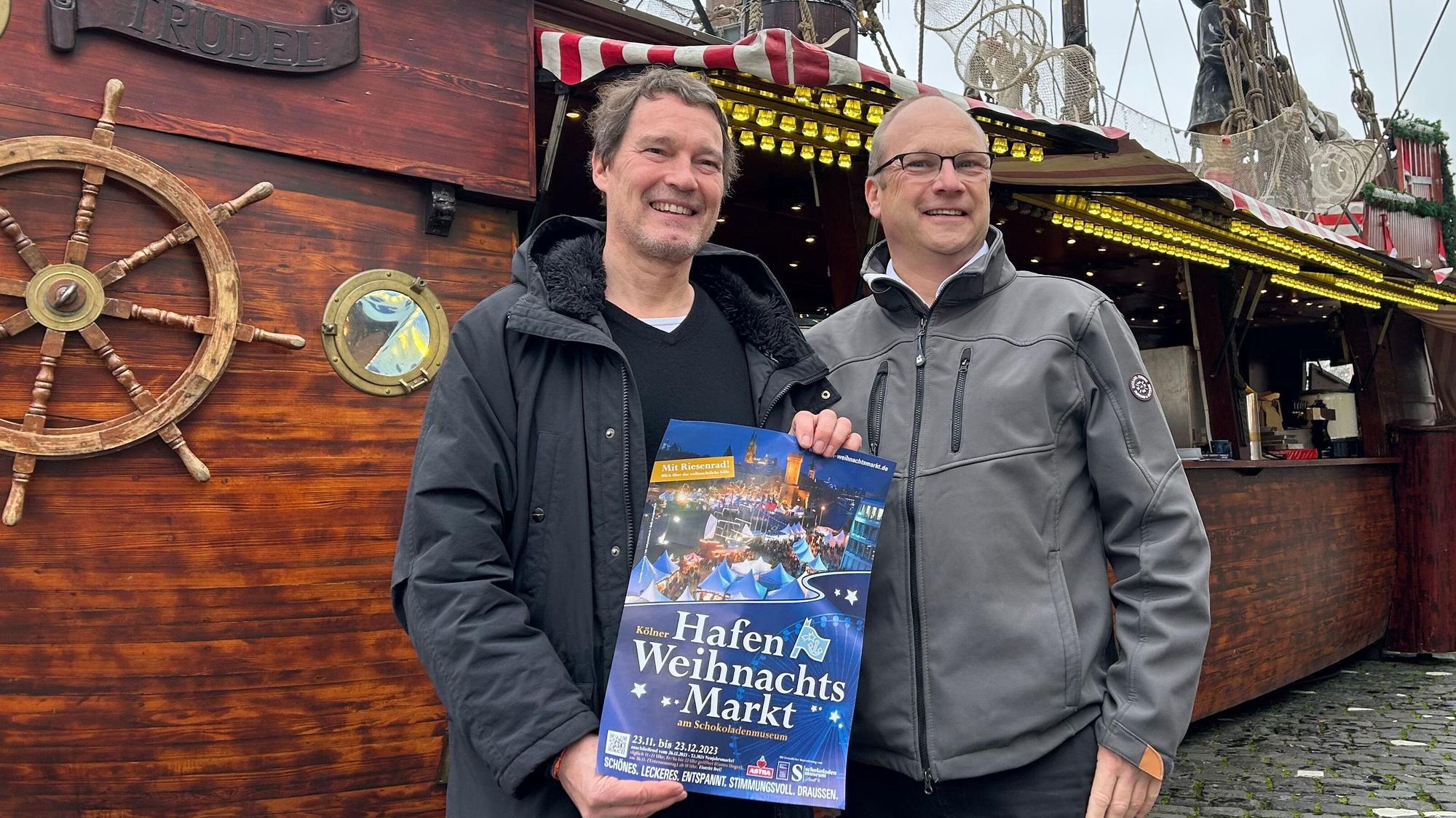 Edwin Kroll und Klaus Schopen stehen vor einem Schiff.