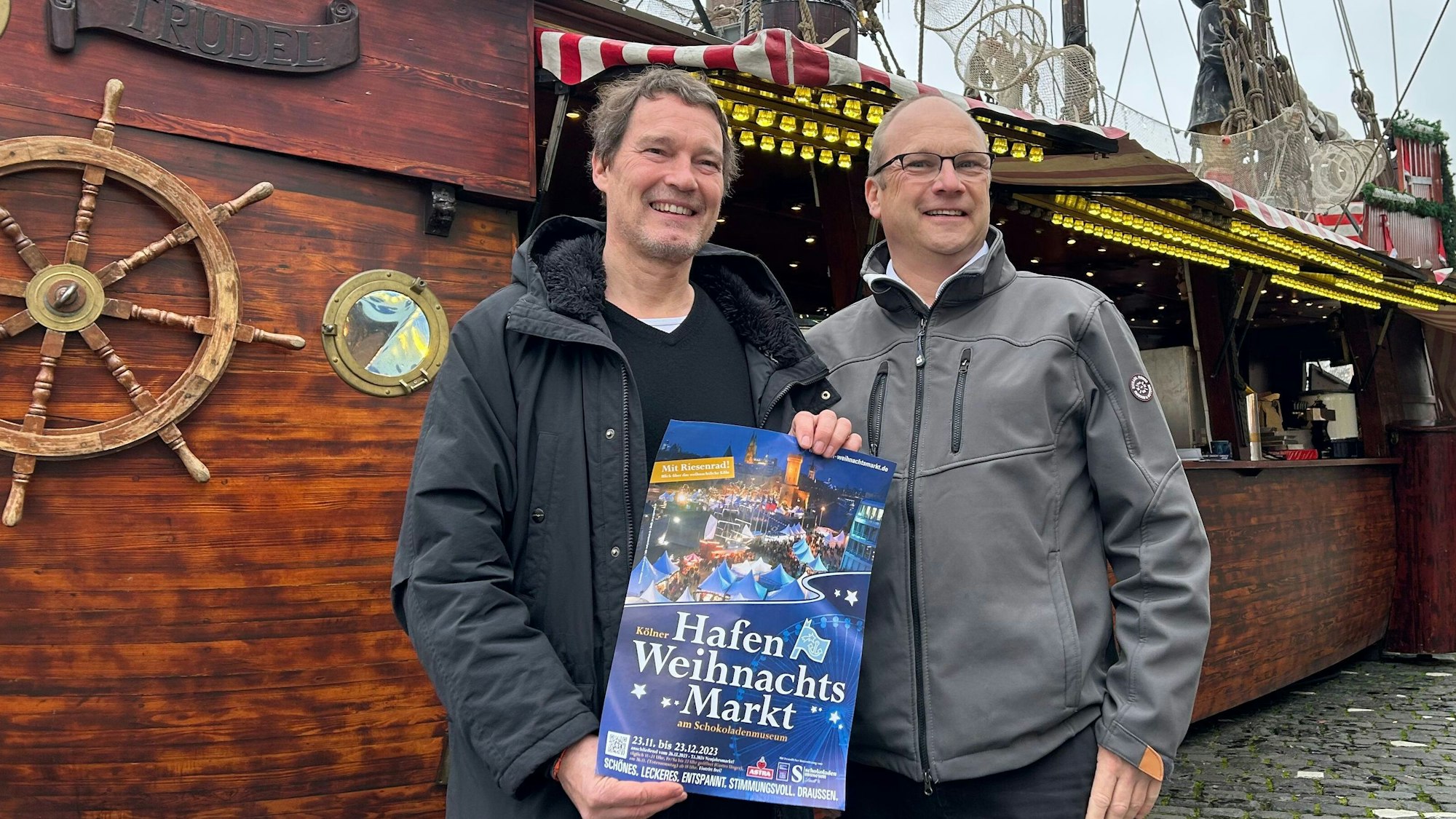 Edwin Kroll und Klaus Schopen stehen vor einem Schiff.