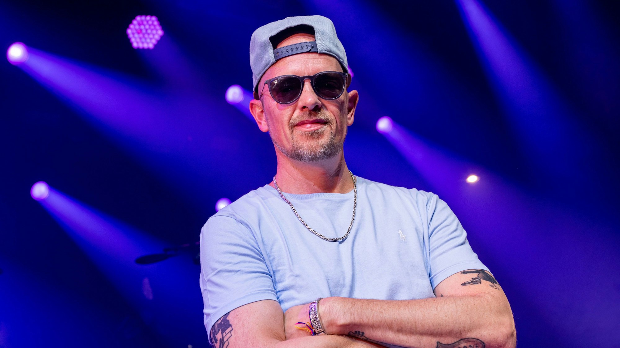 Der Musiker Jan Delay, steht vor einem Interview-Termin mit der Deutschen Presse Agentur auf einer Bühne auf dem Tollwood-Gelände.