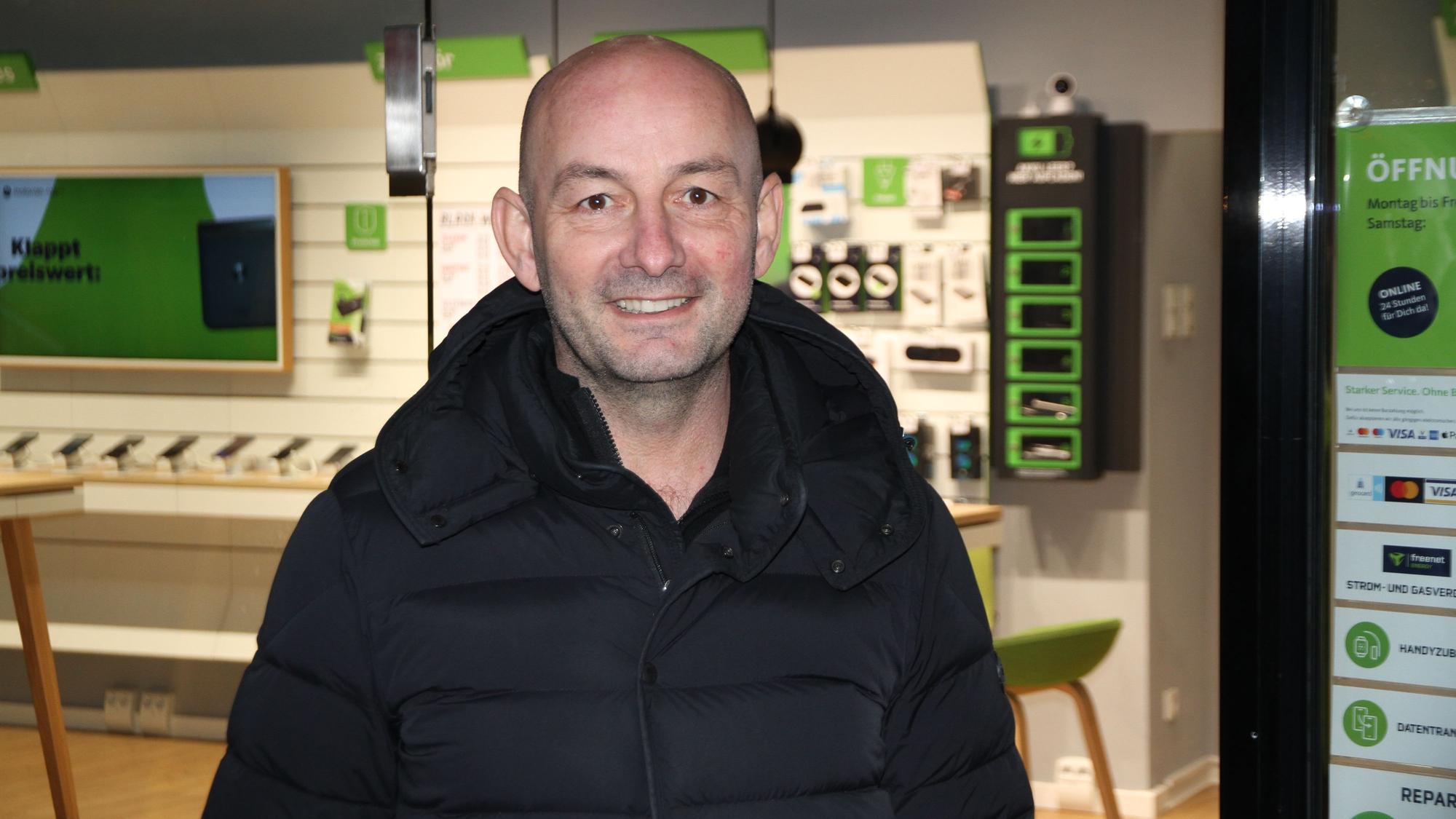 Ein Mann vor dem Schaufenster eines Telefonshops