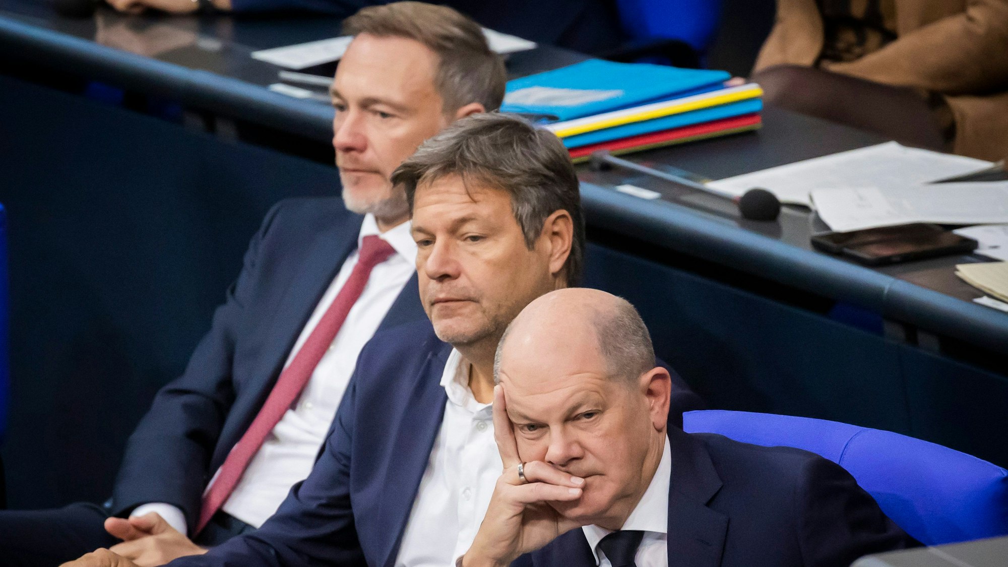 Bundeskanzler Olaf Scholz (SPD, r-l), Robert Habeck (Bündnis 90/Die Grünen), Bundesminister für Wirtschaft und Klimaschutz, und Christian Lindner (FDP), Bundesminister der Finanzen, verfolgen im Plenum des Deutschen Bundestages die Debatte.