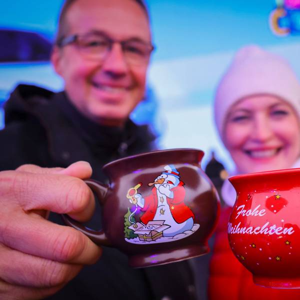 13.11.2023, Hamburg: Ein Paar hält zwei Tassen mit heißem Glühwein kurz nach der Eröffnung des "Santa Pauli" Weihnachtsmarkt· auf dem Spielbudenplatz. Am Montag wurde der sündige Weihnachtsmarkt ·Santa Pauli· auf der Reeperbahn eröffnet. Foto: Christian Charisius/dpa +++ dpa-Bildfunk +++