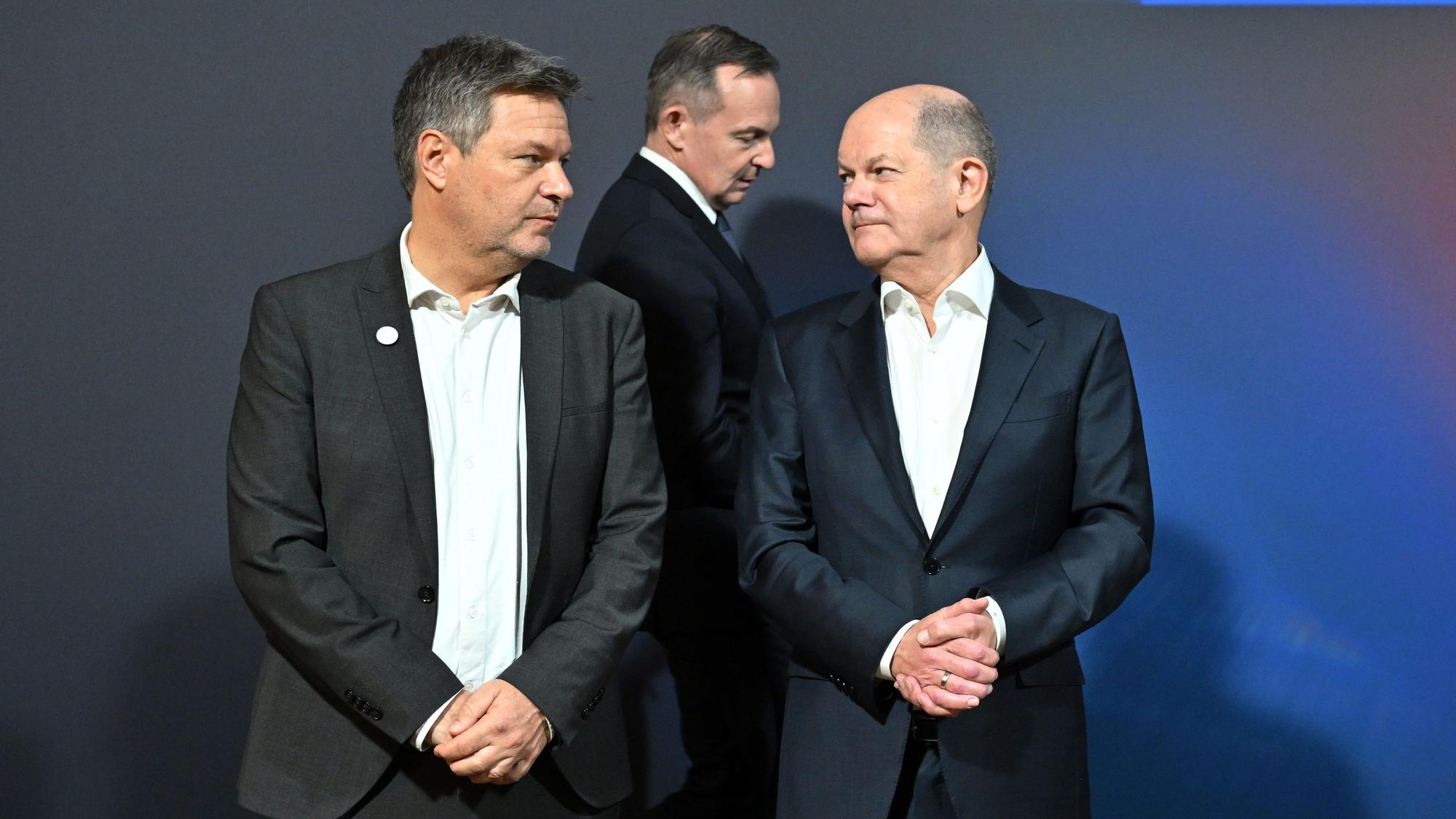 Thüringen, Jena: Robert Habeck (Bündnis90/Die Grünen, l-r), Bundesminister für Wirtschaft und Klimaschutz, Volker Wissing (FDP), Bundesminister für Digitales und Verkehr, und Bundeskanzler Olaf Scholz (SPD), stehen nebeneinander beim Exponatenrundgang beim Digital-Gipfel 2023.