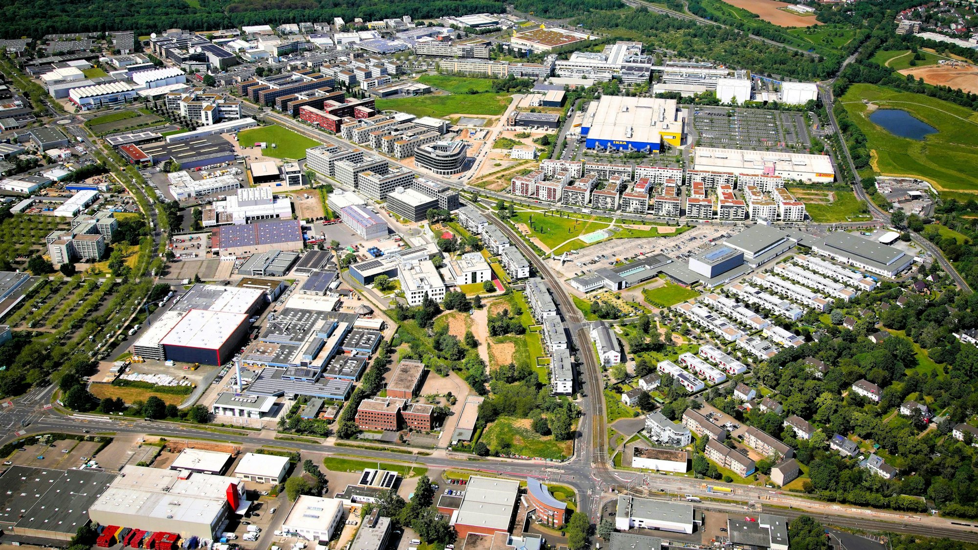 Blick aus der Luft auf ein Viertel mit Wohnbebauung und großen Gewerbeflächen.