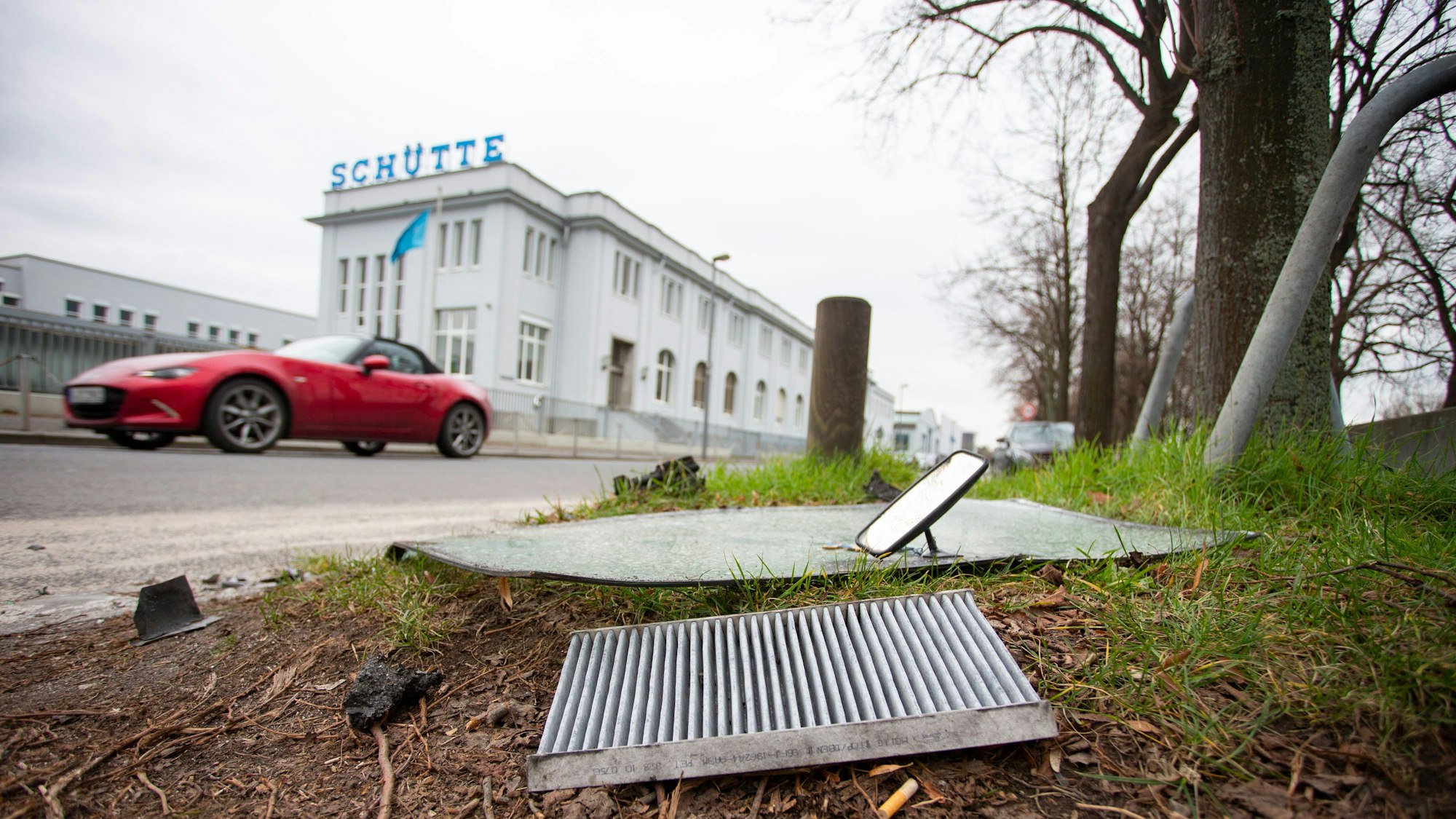Ein rotes Auto fährt auf der Alfred-Schütte-Allee.