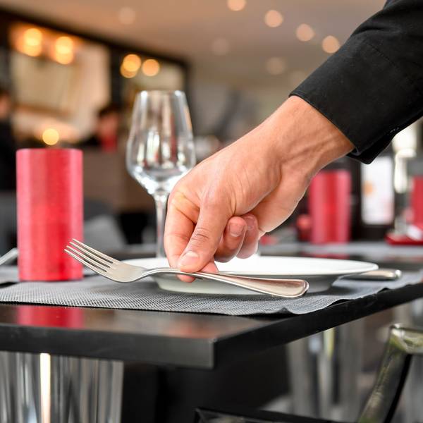 Ein Tisch wird in einem Restaurant wird eingedeckt.