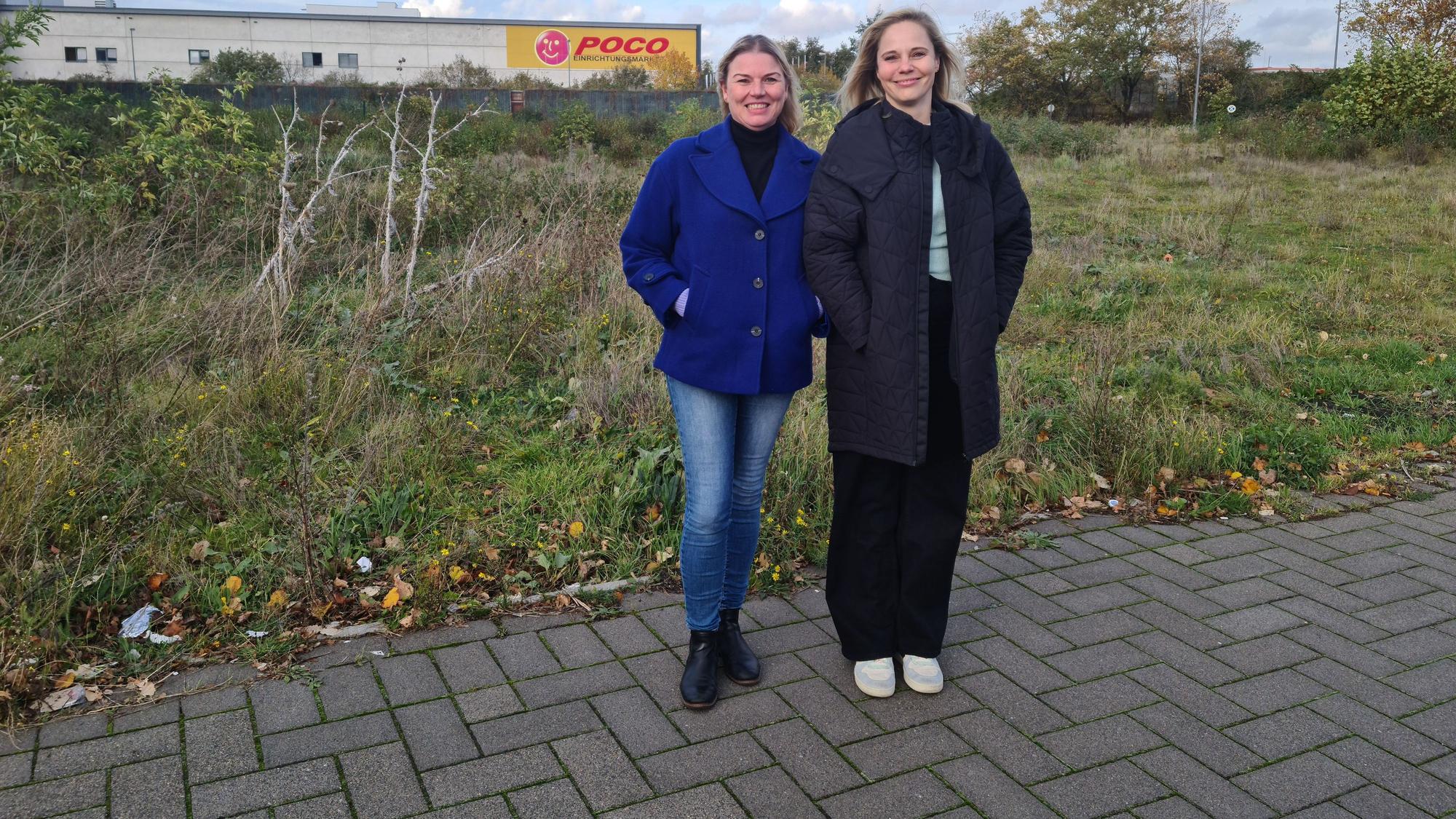 Zwei Frauen stehen vor einer Wiese, im Hintergrund ist der Poco-Markt zu erkennen.