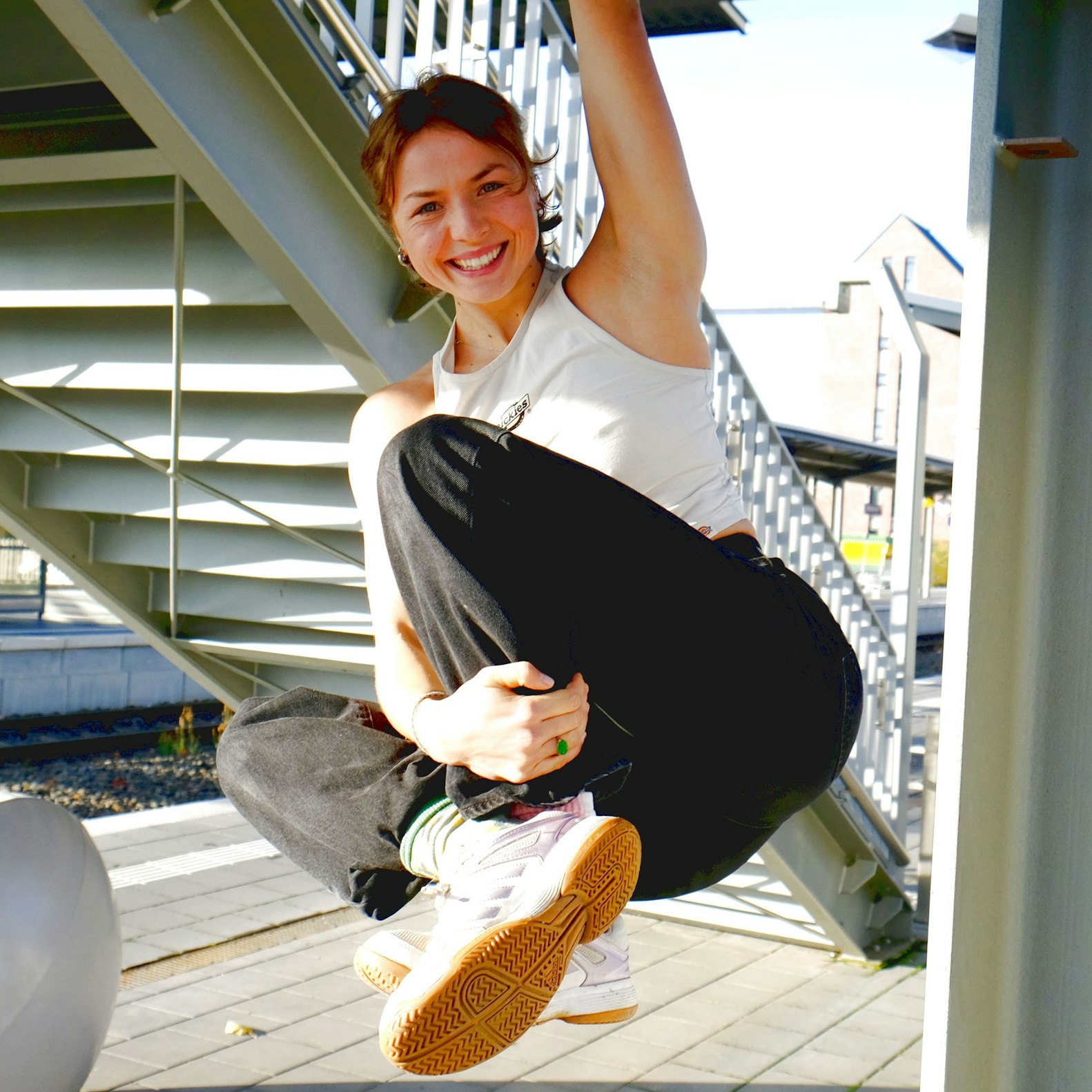 Ada Theilken hält sich mit einer Hand an einer Brückenkonstruktion aus Metall fest.