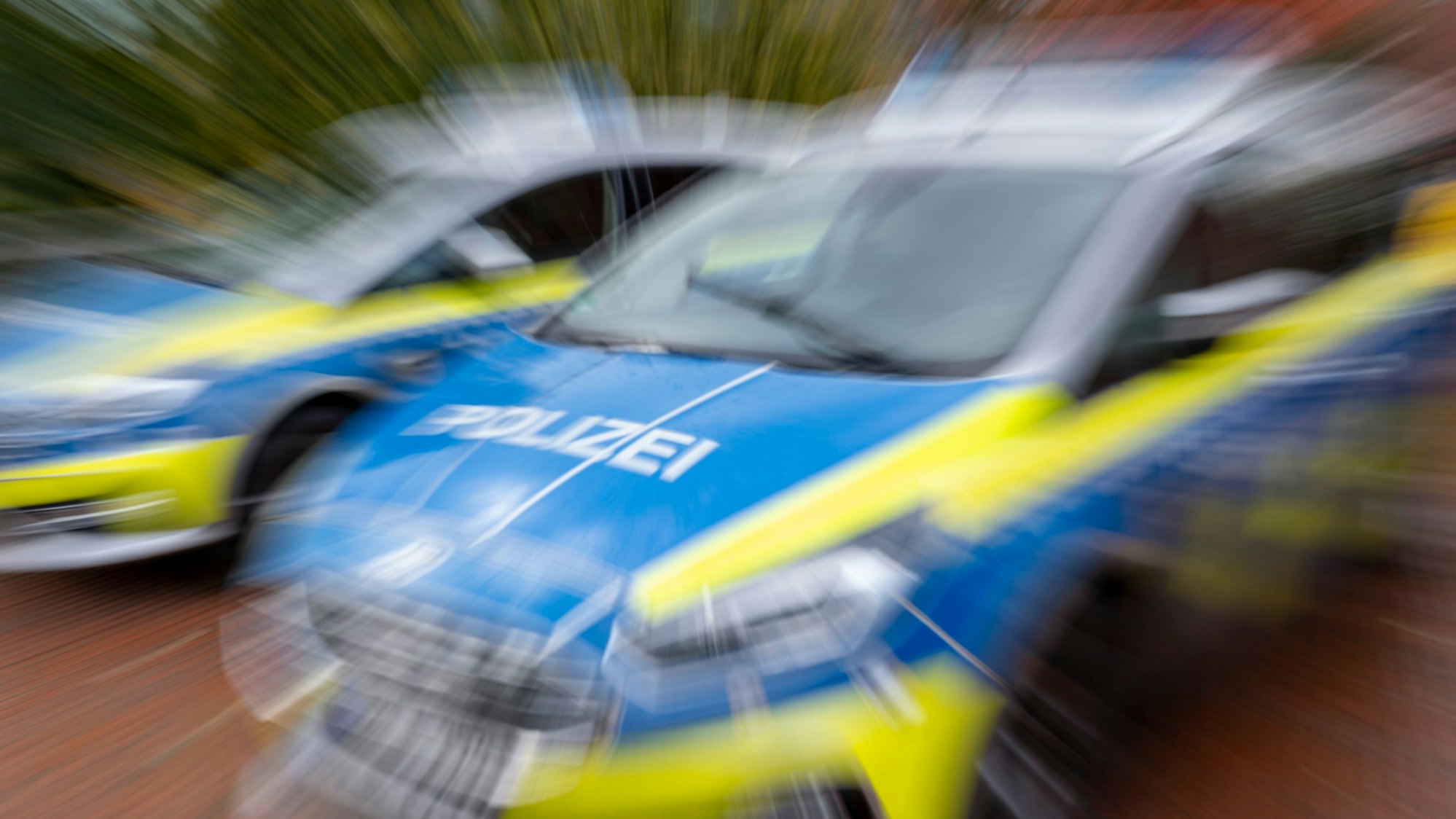 Zwei Polizeiautos, fotografiert mit Bewegungsschärfe