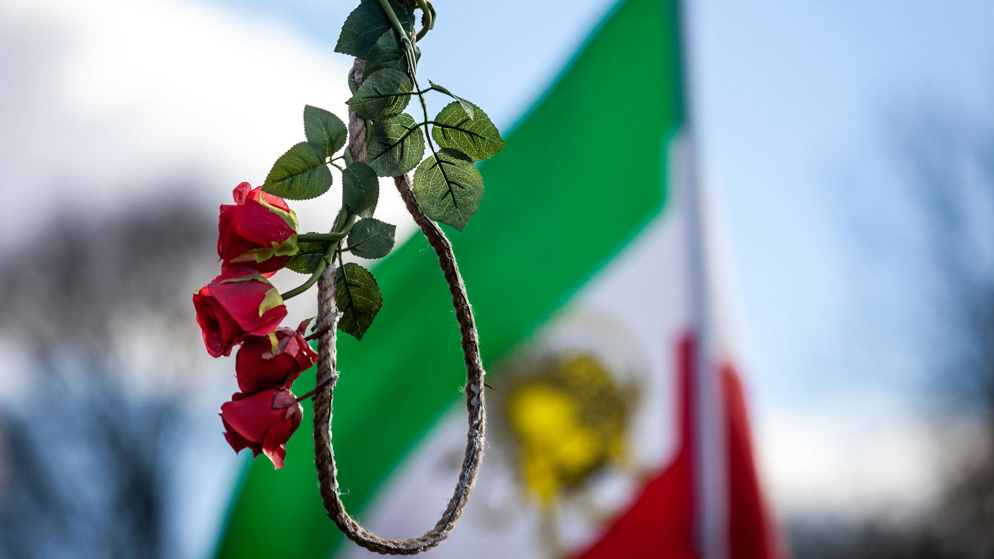 Während einer Kundgebung gegen die Hinrichtung von Demonstranten im Iran durch das islamische Regime hängt eine mit Rosen geschmückte Schlinge an einem Galgen.