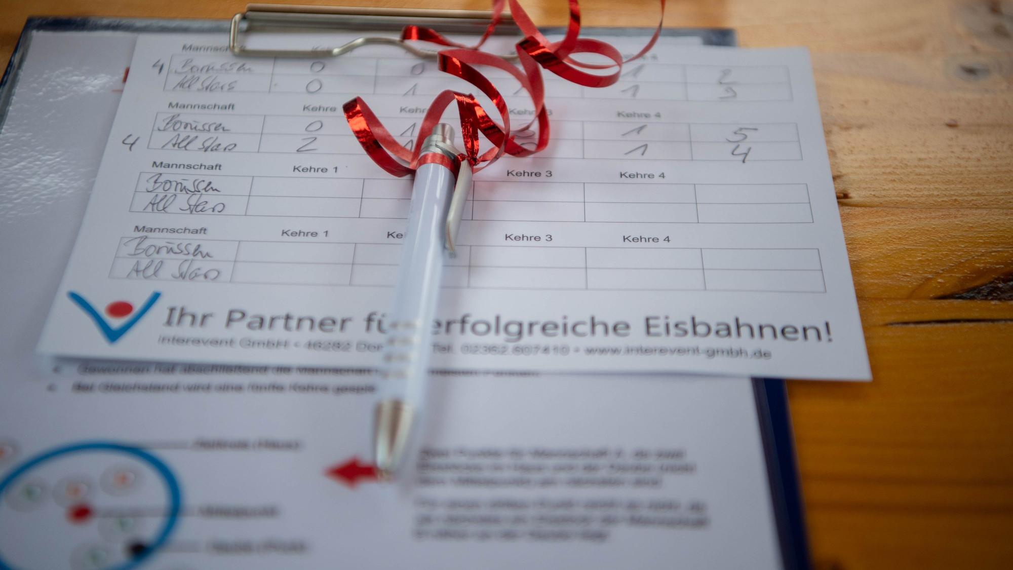 Das Bild zeigt einen Ergebniszettel mit einem Stift.
