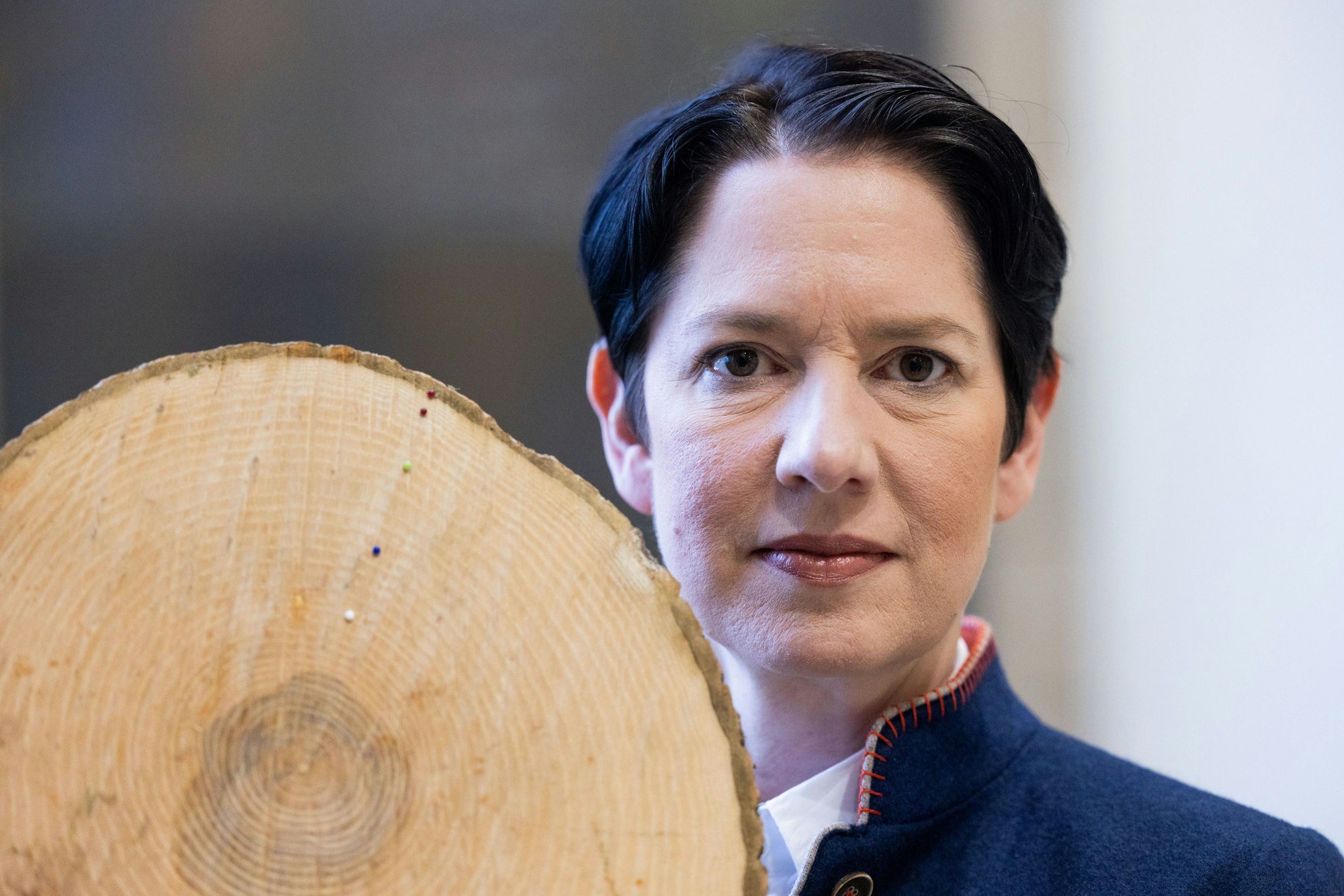 Silke Gorißen (CDU), Landwirtschaftsministerin von Nordrhein-Westfalen, zeigt einen Querschnitt einer Esche, an der mithilfe von Nadelköpfen das verringerte Wachstum dargestellt wird.