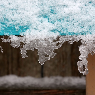Schnee und Eis hängen an einer Informationstafel im Rheinpark in Köln. In Köln und der Region werden Ende November zweistellige Minusgrade und der erste Schnee erwartet.