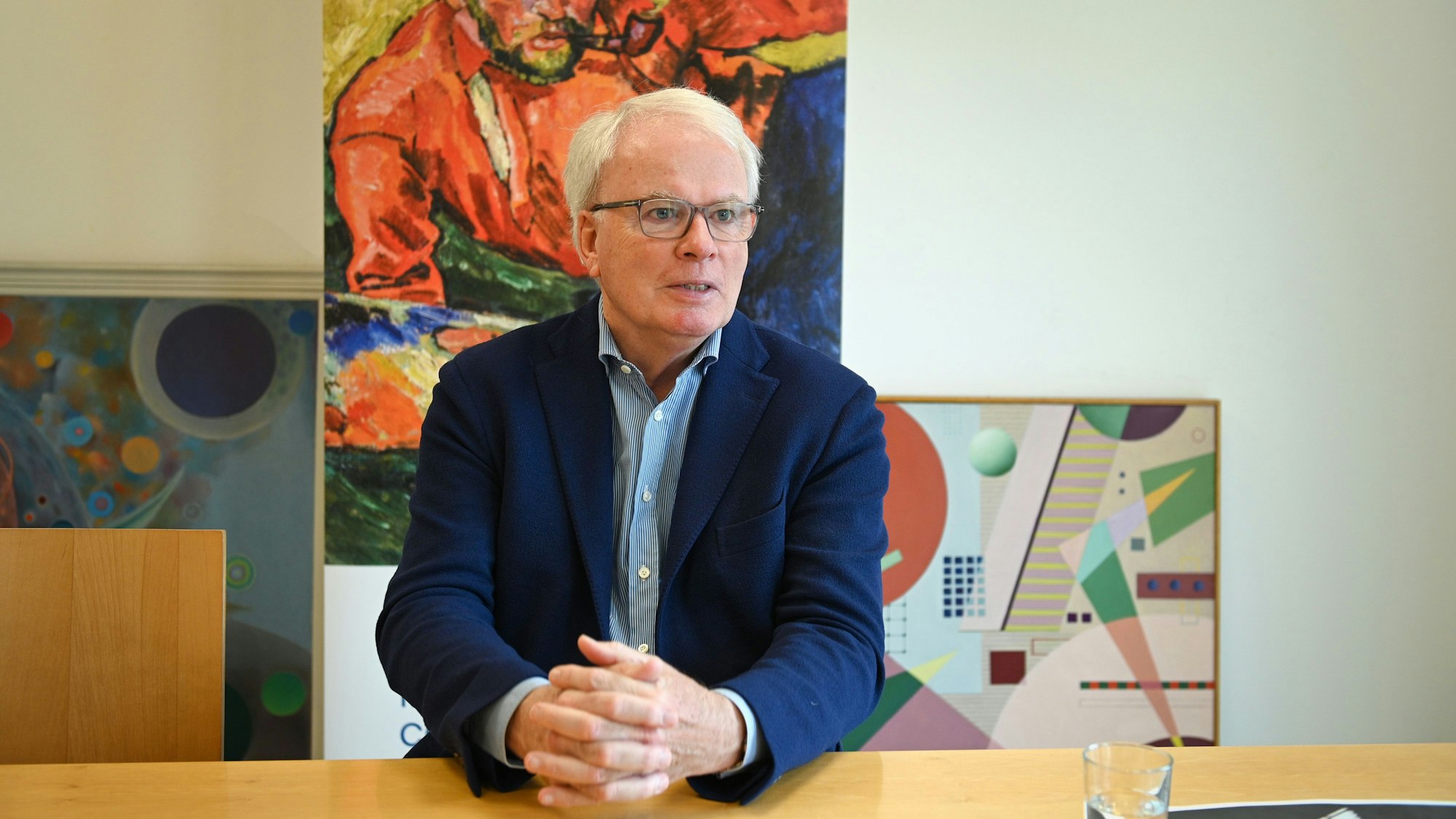 Henrik Hanstein sitzt an einem Tisch.