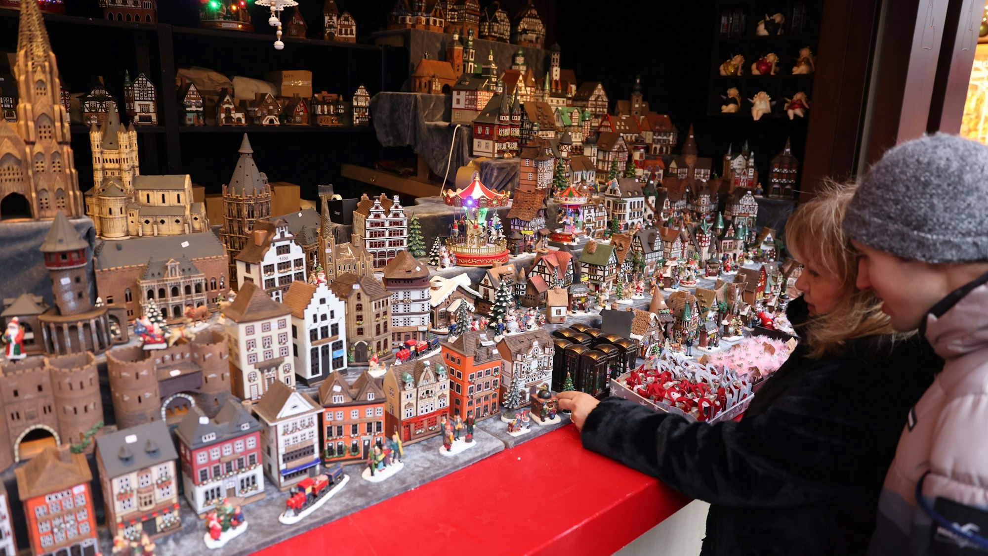 Klein Köln: Im „Keramik-Haus“ auf dem Weihnachtsmarkt am Dom findet sich die Stadt im Kleinformat, darunter viele Brauhäuser, Torburgen und Kirchen. Beleuchtet werden sie durch Teelichter.