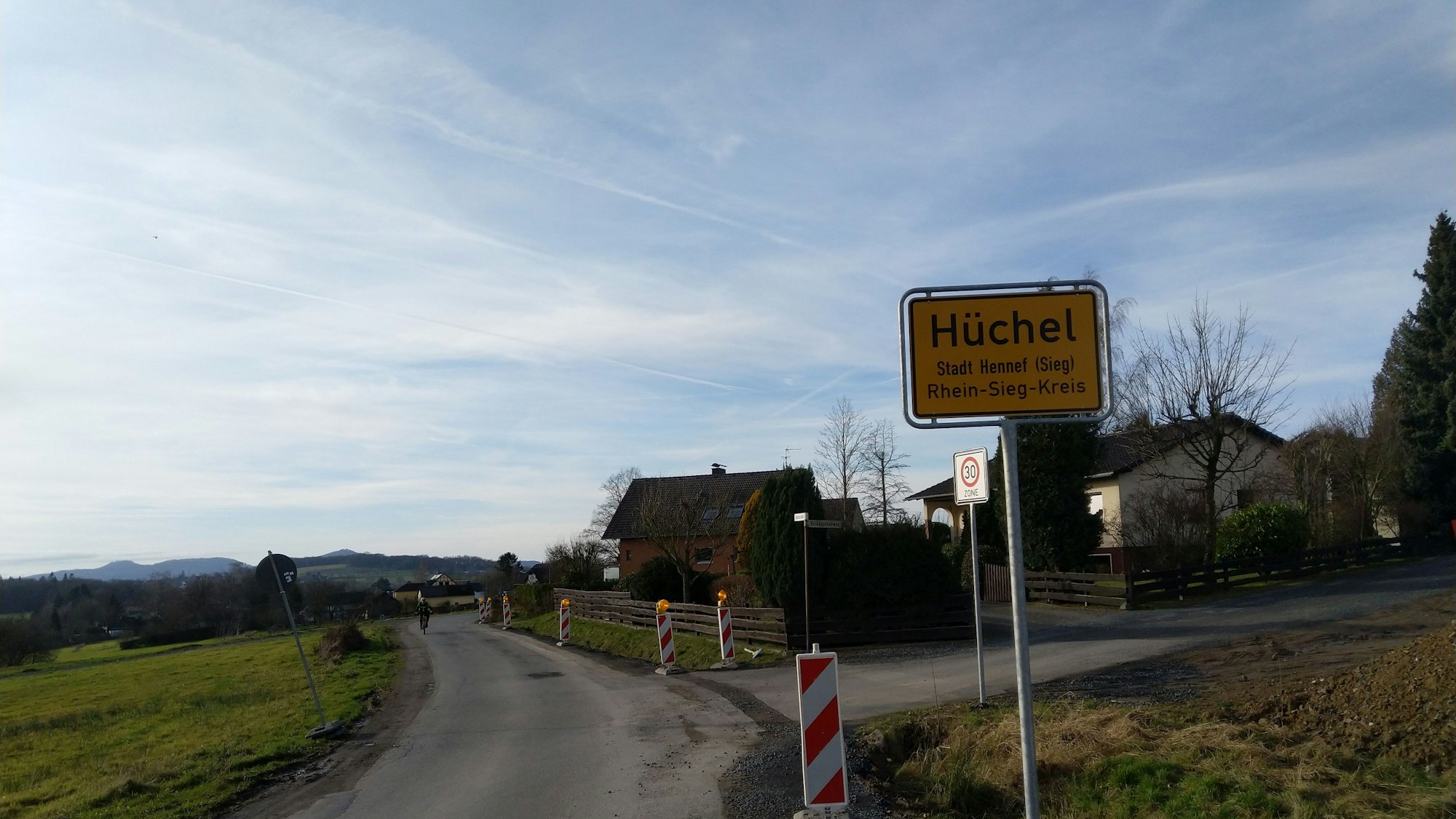 Das Bild zeigt ein Straßenschild an einer Landstraße.