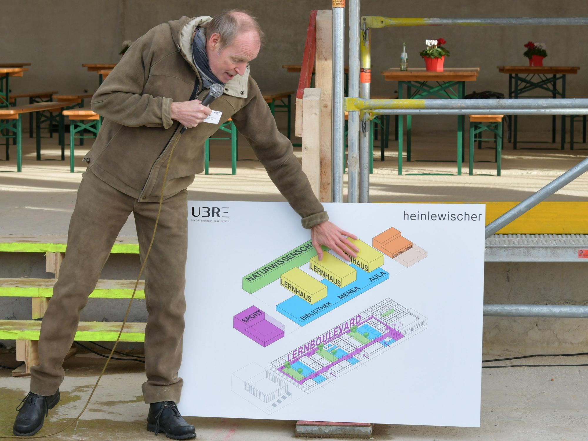 Markus Kill, Partner beim Architekturbüro Heinlewischer, präsentiert den Aufbau des neuen Schulgebäudes beim Richtfest.