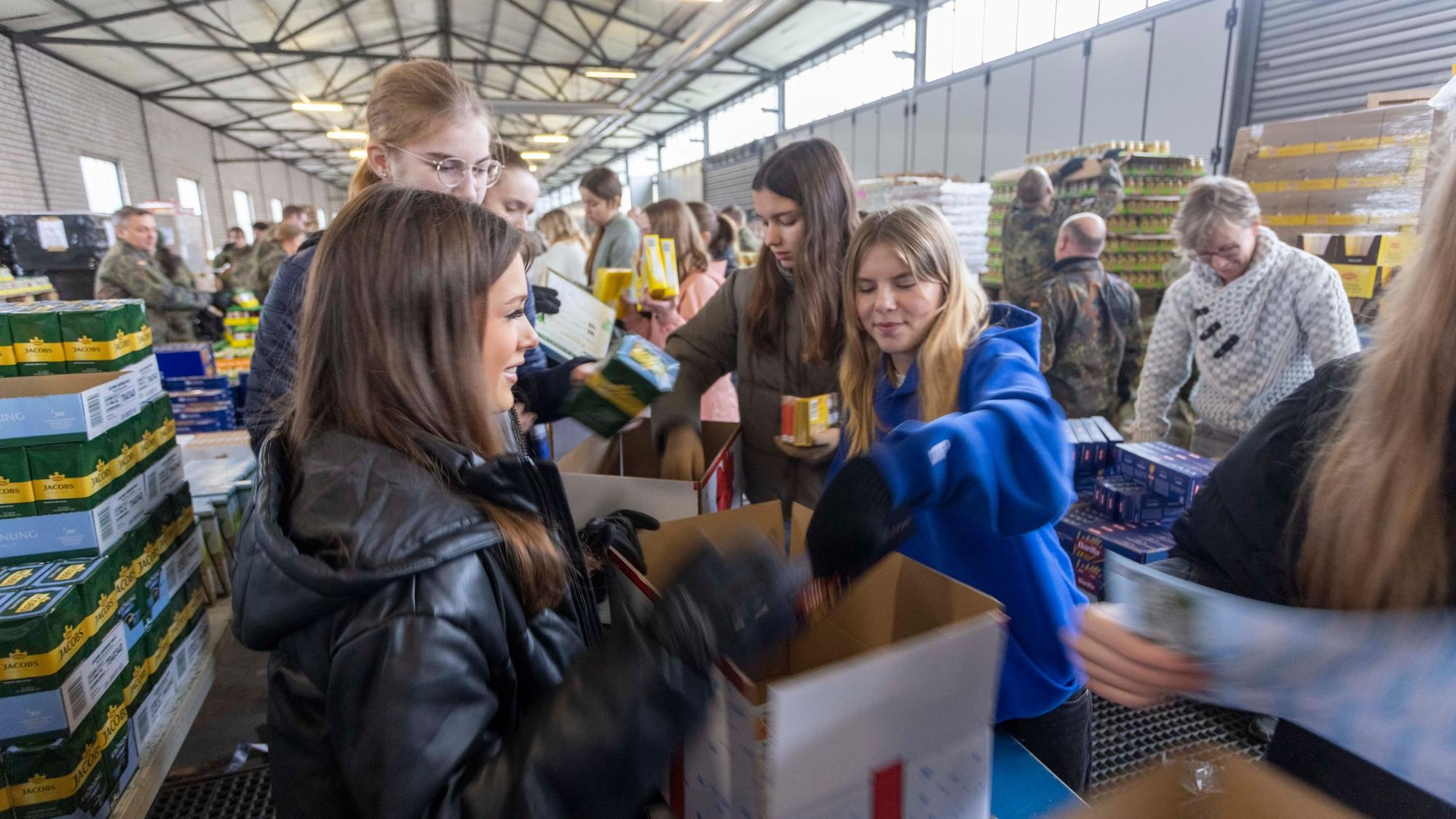 Mädchen vom Ursulinengymnasium helfen mit, die Weihnachtspakete für alte Menschen zu füllen.
