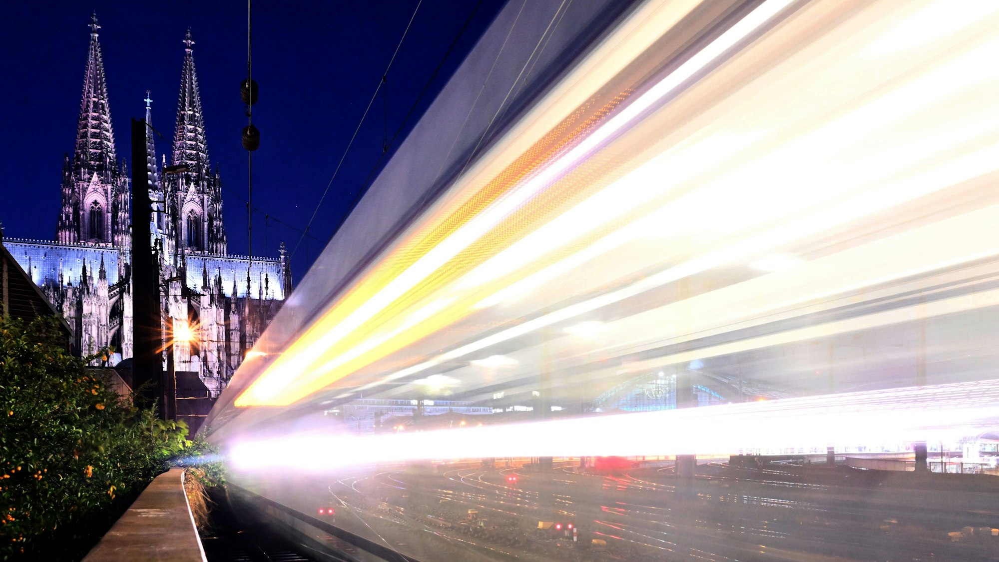 Ein Zug fährt am frühen Morgen am Dom vorbei.