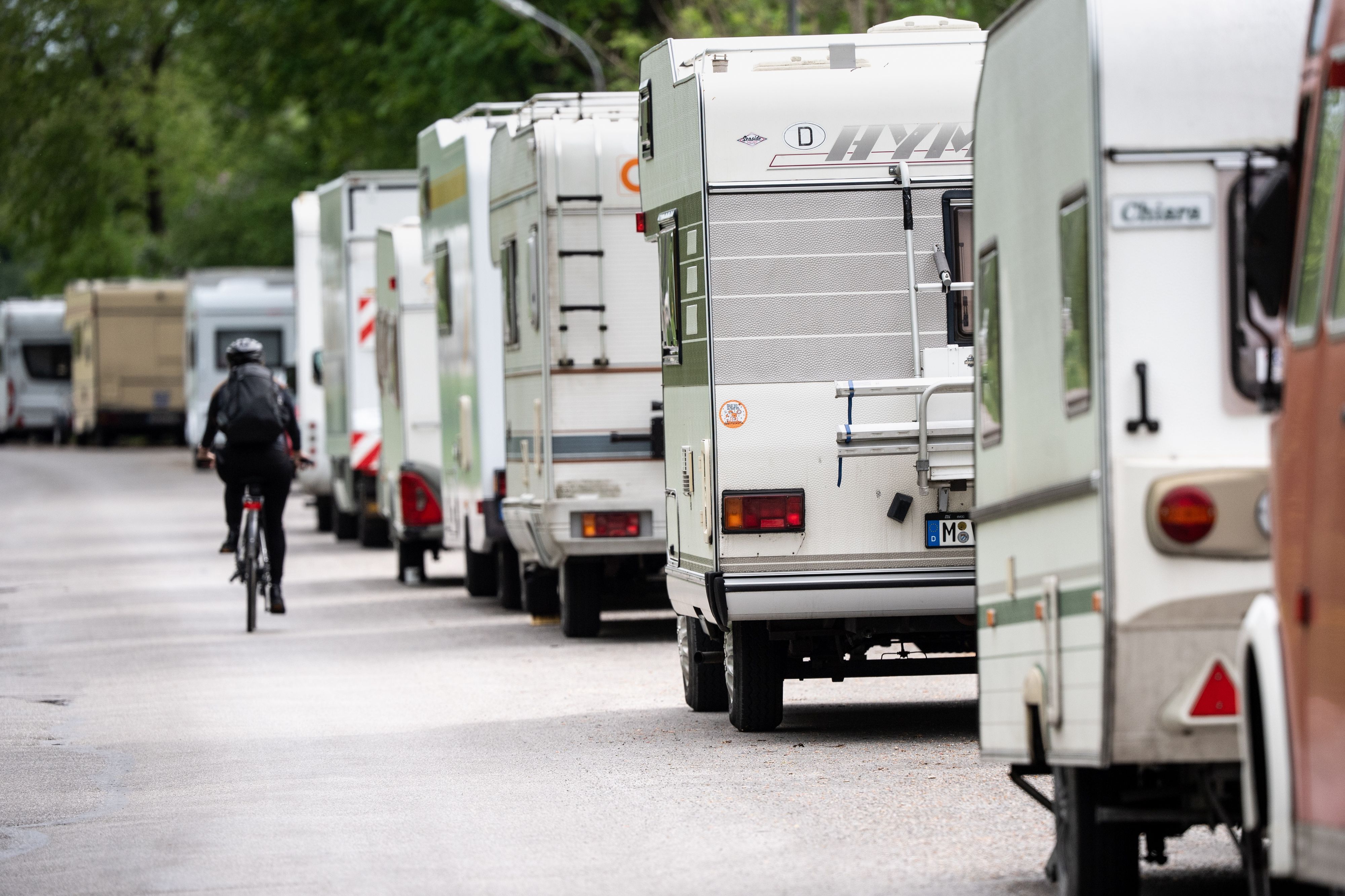 Ein Radfahrer fährt in einer Straße an geparkten Wohnmobilen und Wohnwagen vorbei. (zu dpa «Wohnmobil-Boom verschärft mancherorts Parkplatznot») +++ dpa-Bildfunk +++