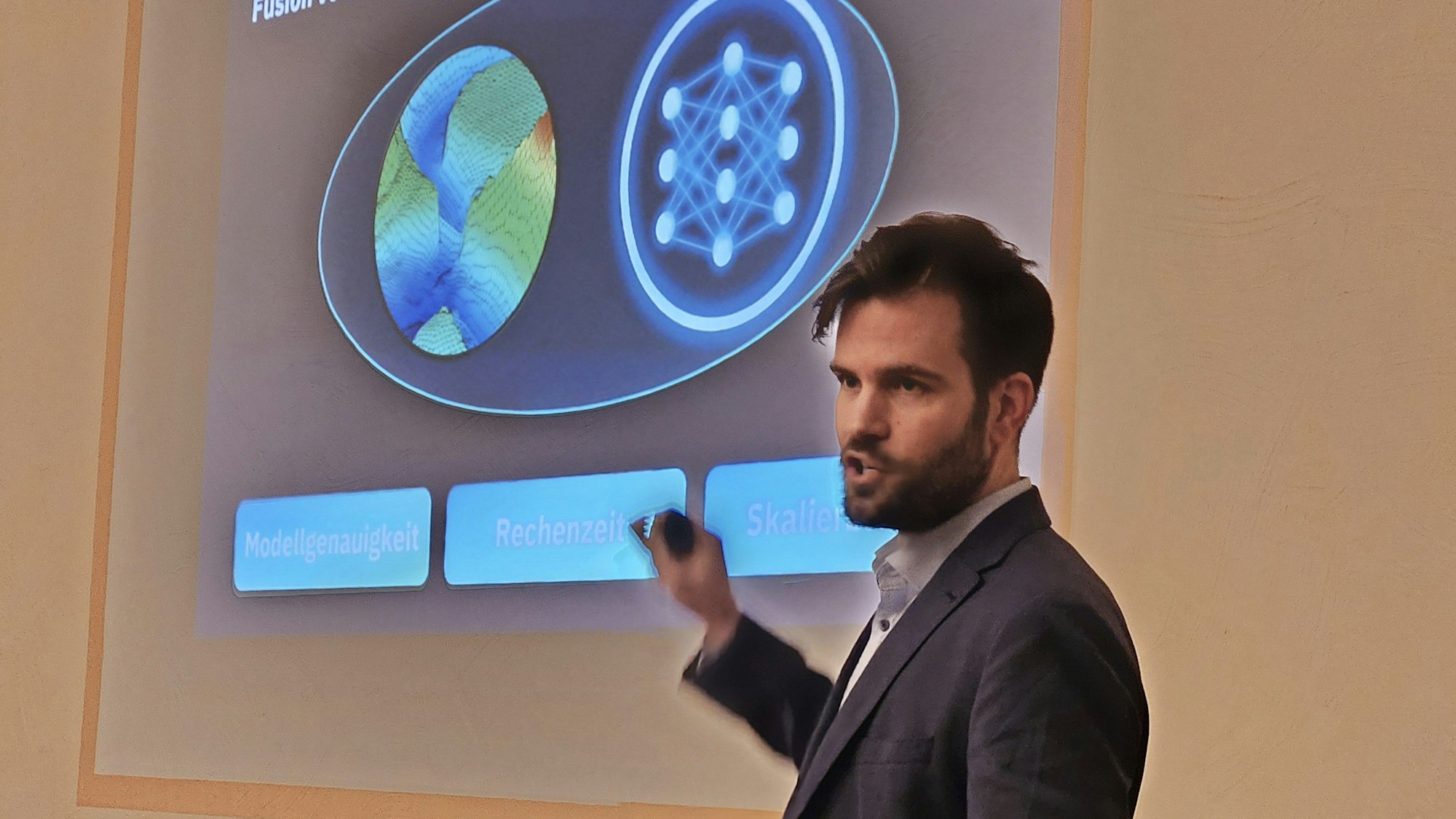 Dr. Julian Hofmann zeigt eine auf eine wand projizierte Abbildung.