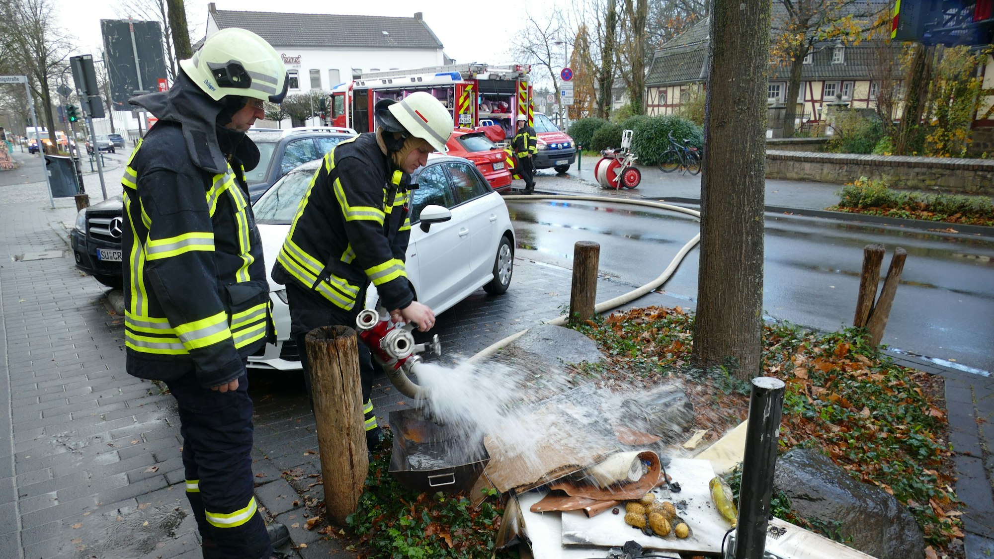 Feuerwehrleute löschen Brandschutt.