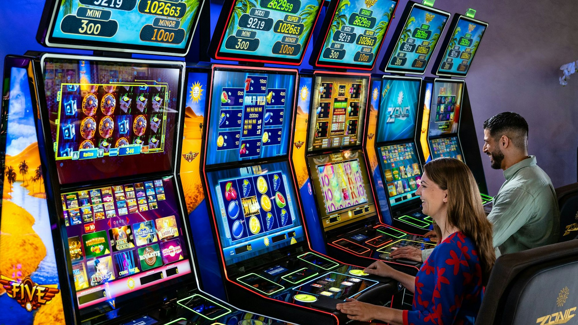 Eine Frau und ein Mann spielen an Glücksspielautomaten