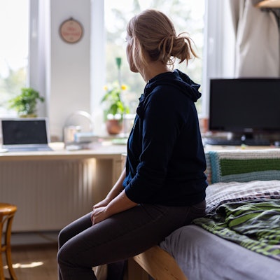 ARCHIV - 13.08.2023, Niedersachsen, Hannover: ILLUSTRATION - Eine Studentin sitzt auf dem Bett in ihrem WG-Zimmer und schaut aus dem Fenster (gestellte Szene).