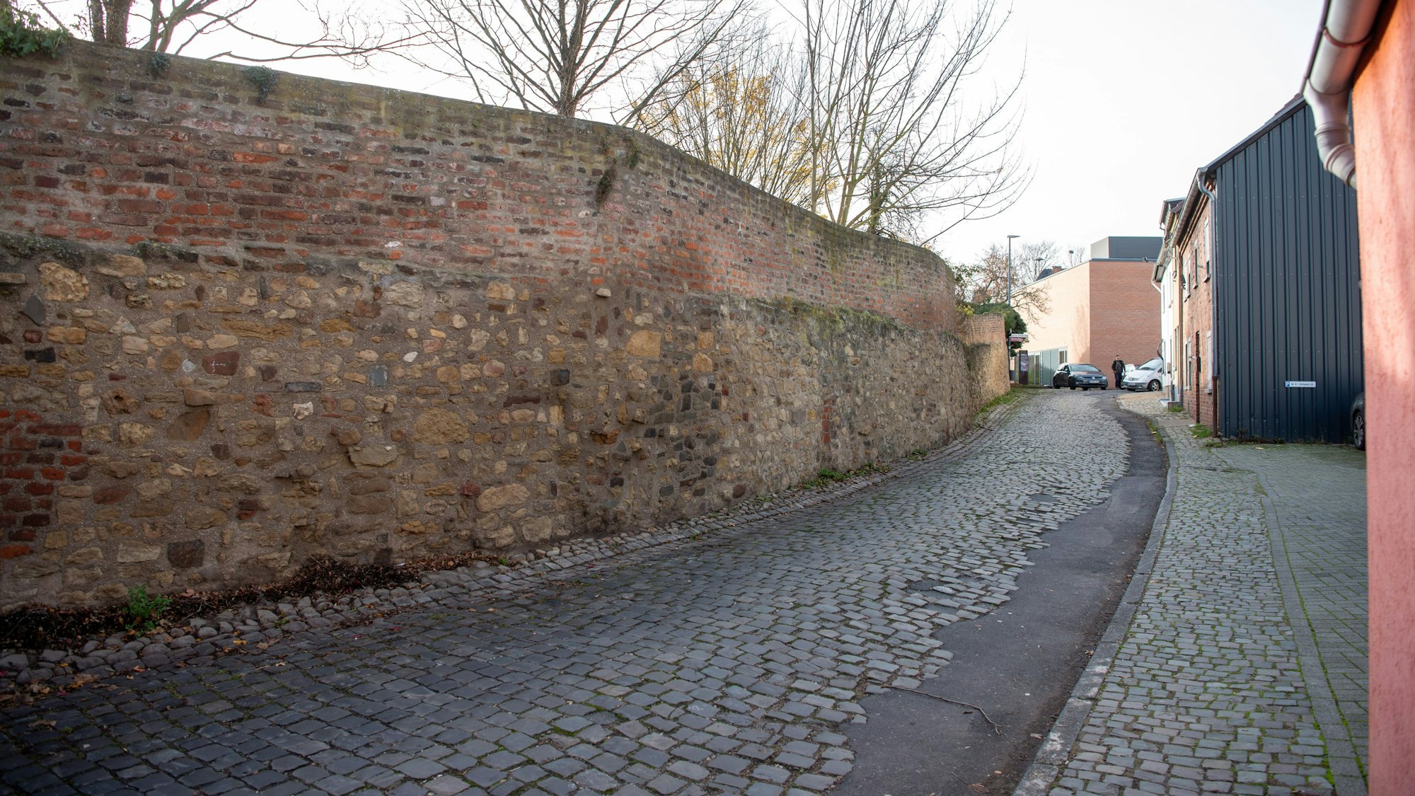 Ein Abschnitt der Zülpicher Stadtmauer verläuft an einer Straße entlang.