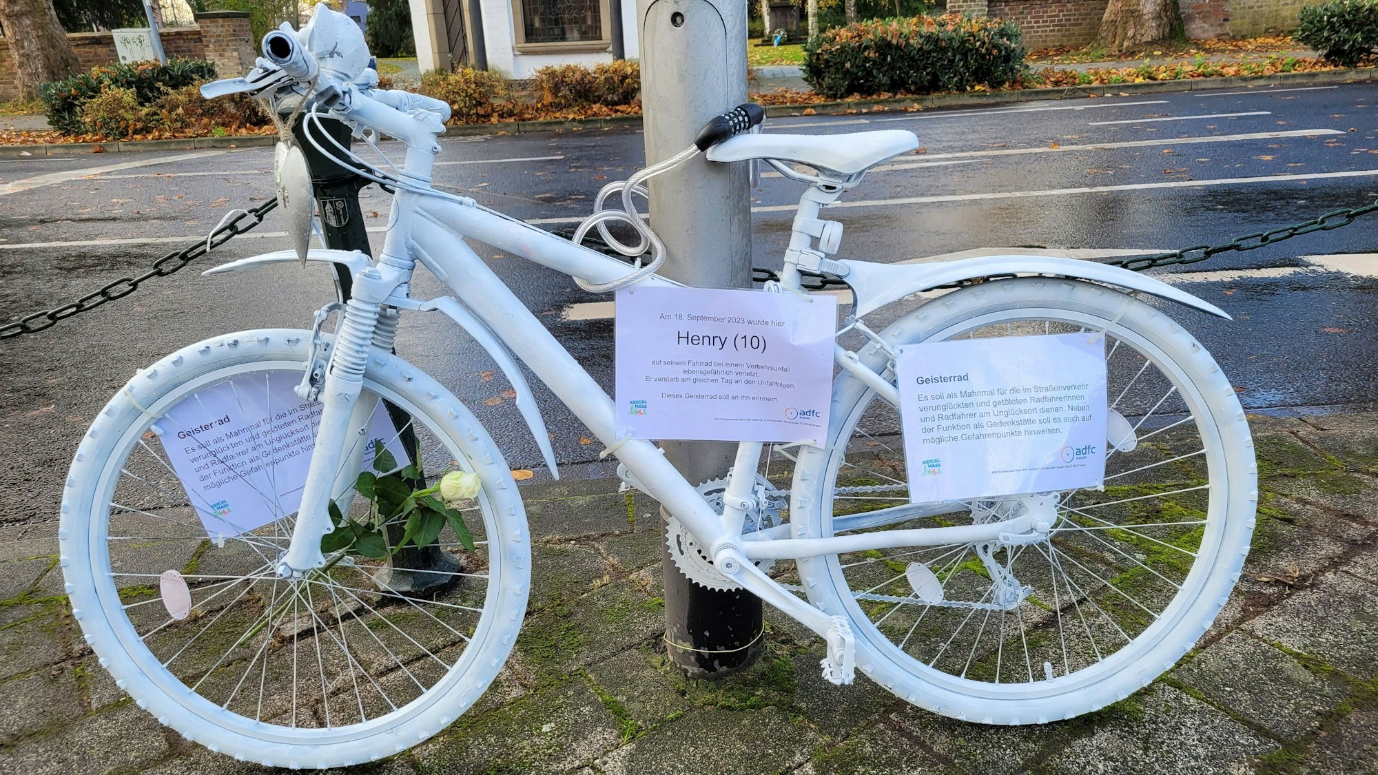 An einer Straßenlaterne nahe der Unfallstelle lehnt das weiß gestrichene Geisterfahrrad.