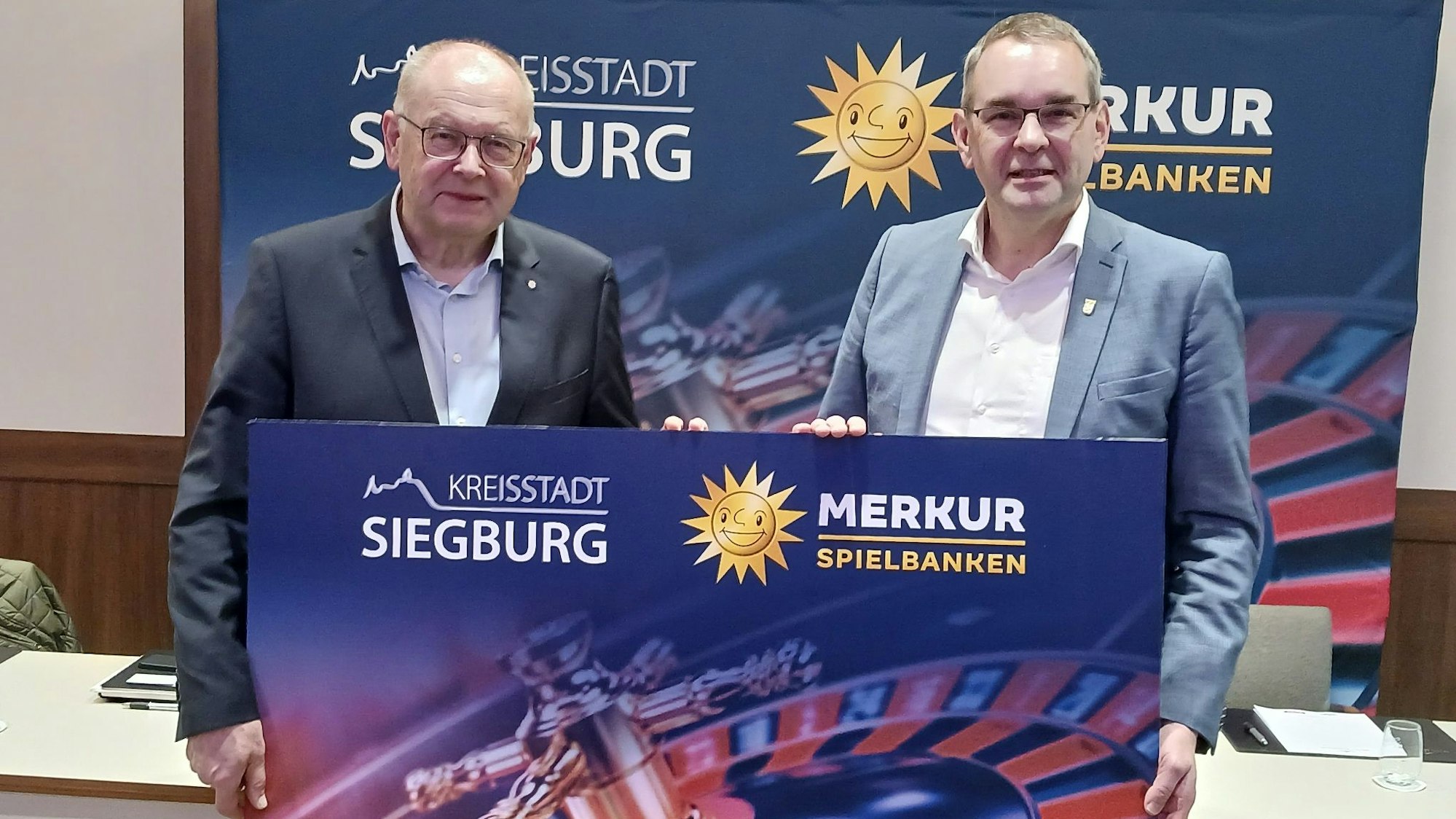 Zwei Männer mit einem Werbeplakat für eine Spielbank, das eine Roulettescheibe zeigt