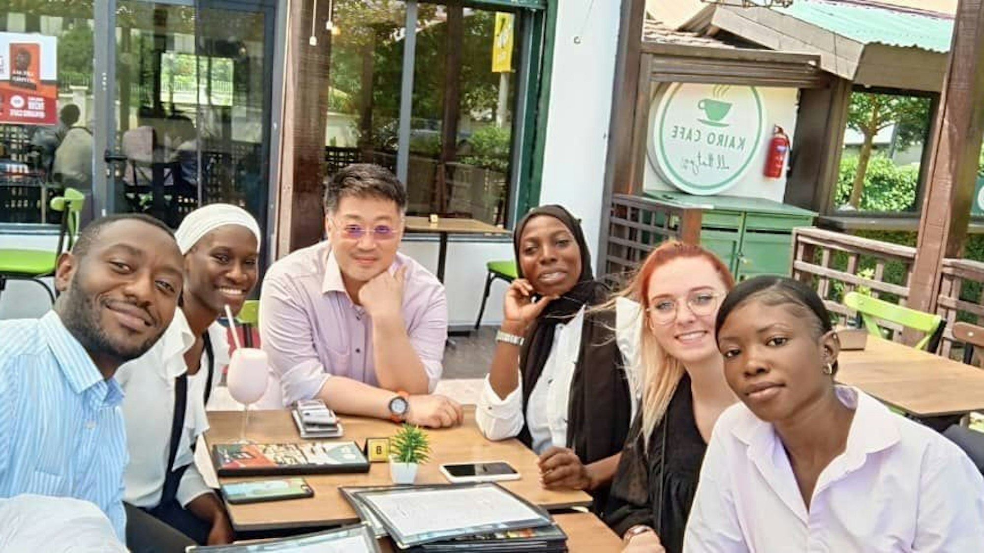 Auf dem Bild sind Arbeitskollegen zu sehen, die gemeinsam in einem Restaurant in Gambia sitzen.