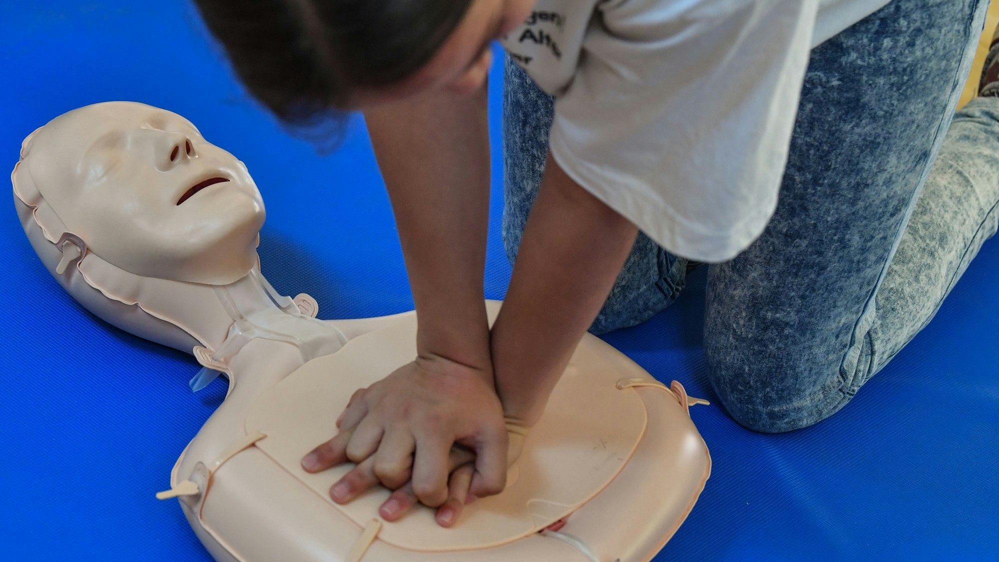 Eine Schülerin übt die Wiederbelebung an einem Dummy.