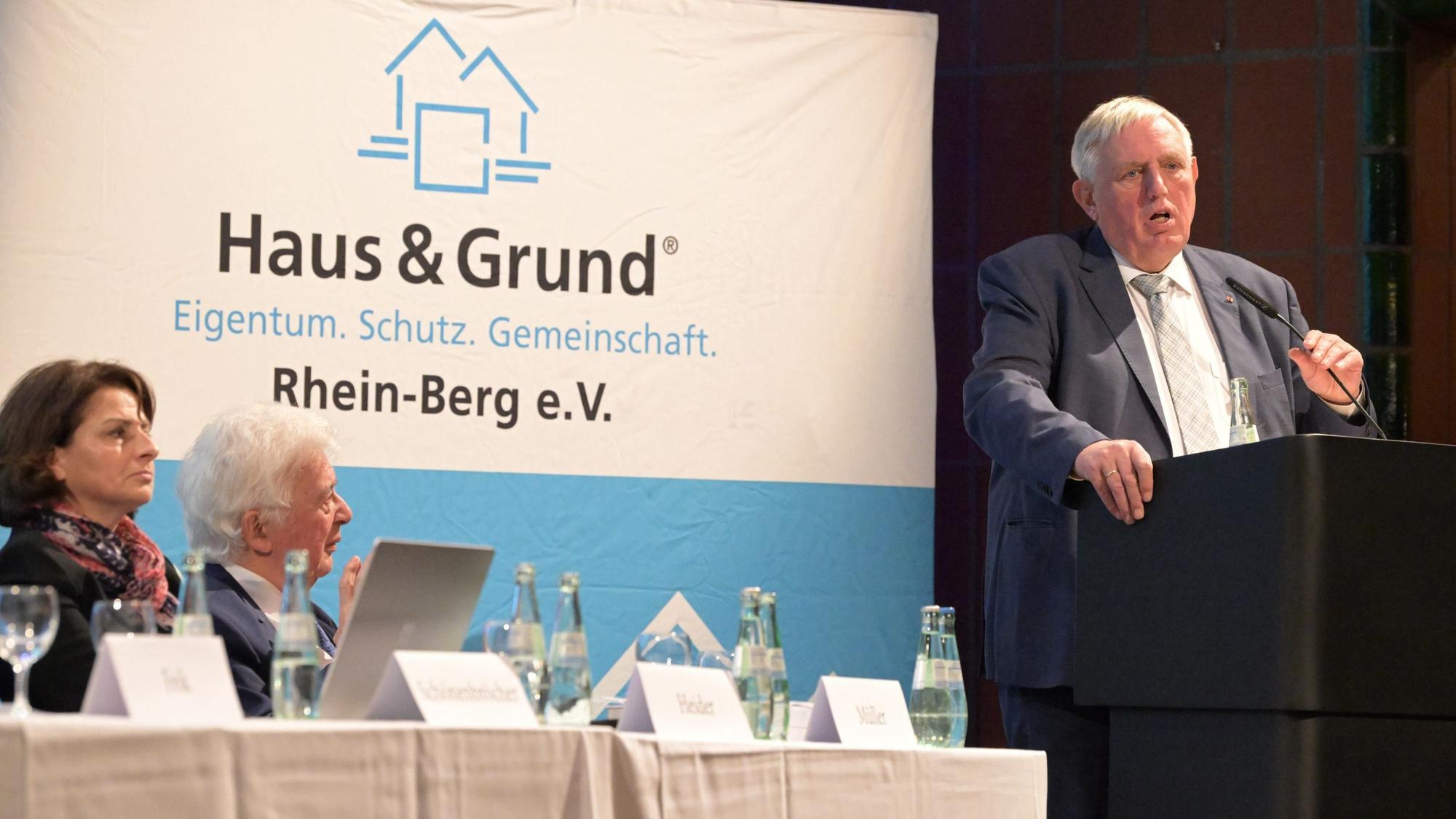 Minister Karl-Josef Laumann steht am Rednerpult auf einer Bühne, im Hintergrund ist der Schriftzug von Haus & Grund Rhein-Berg zu lesen.
