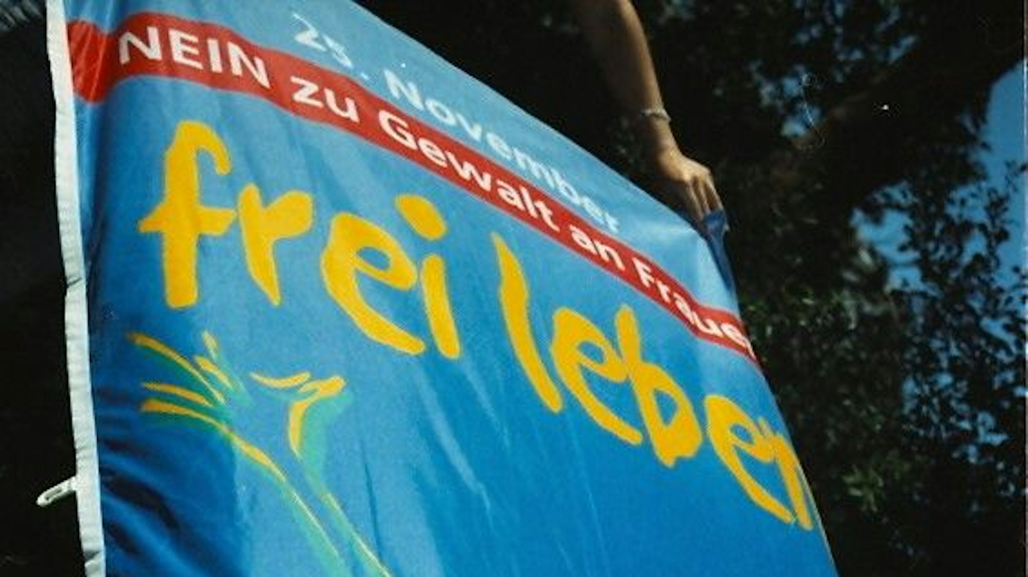 Eine Fahne zeigt die Aufschrift: "25. November, Nein zu Gewalt an Frauen, frei leben."