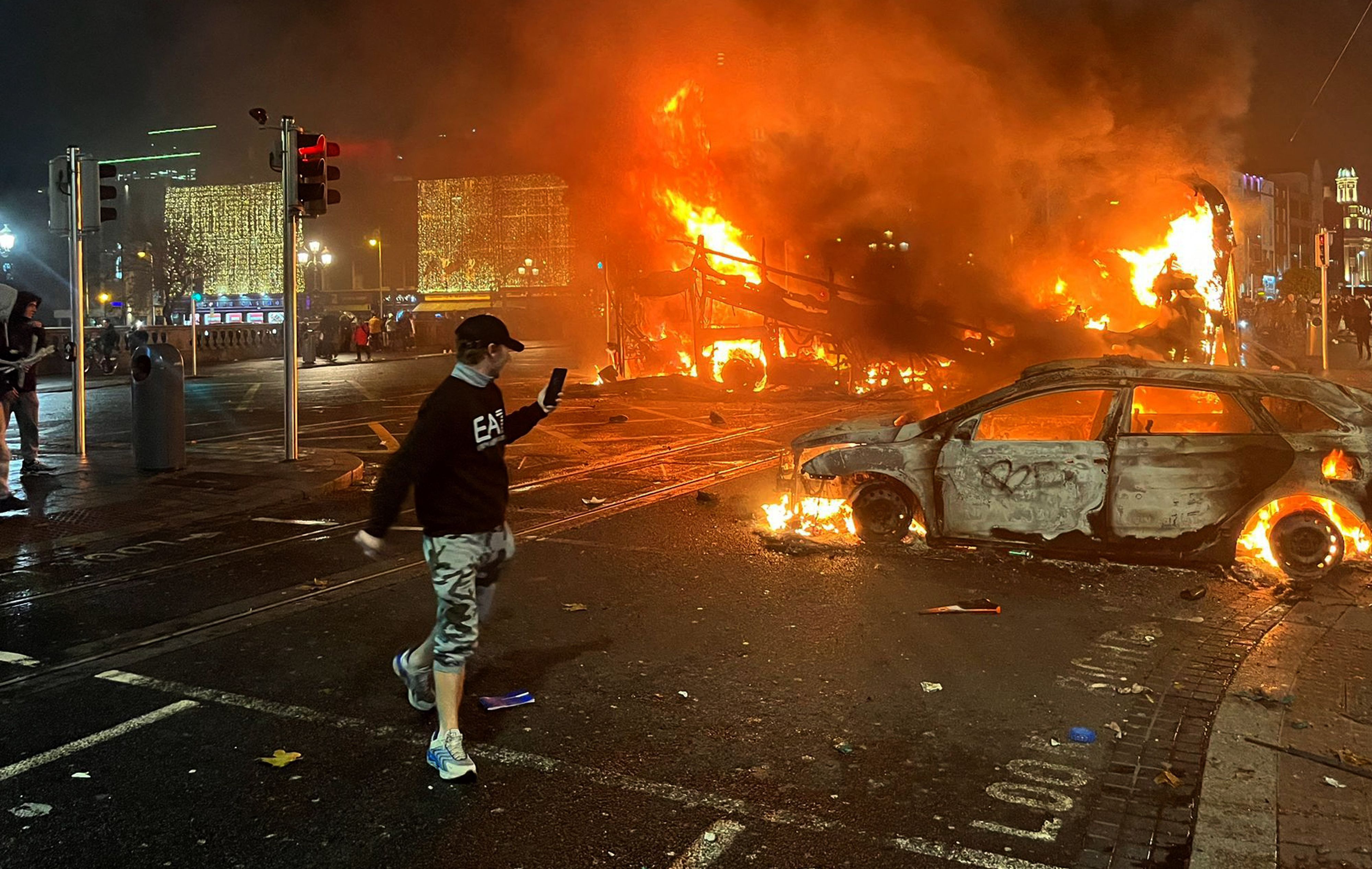 Ein Bus und ein Auto brennen in der O'Connell Street im Stadtzentrum von Dublin. Nach einem Messerangriff in der irischen Hauptstadt kam es am Abend in der Nähe des Tatorts zu schweren Ausschreitungen.