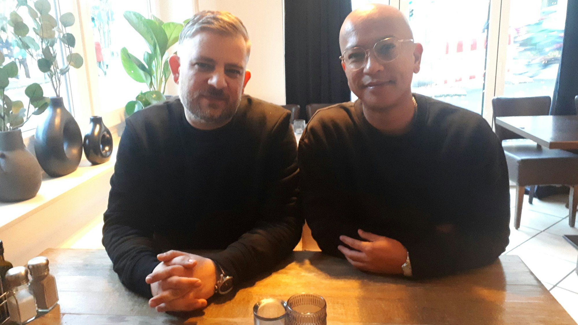 Zwei Männer sitzen am Tisch.