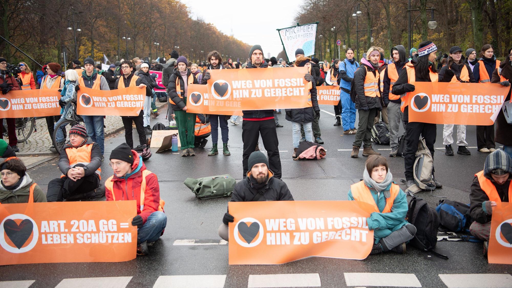 Aktivisten der Klimaschutzgruppe "Letzte Generation" und anderer Gruppierungen blockieren die Straße des 17. Juni.